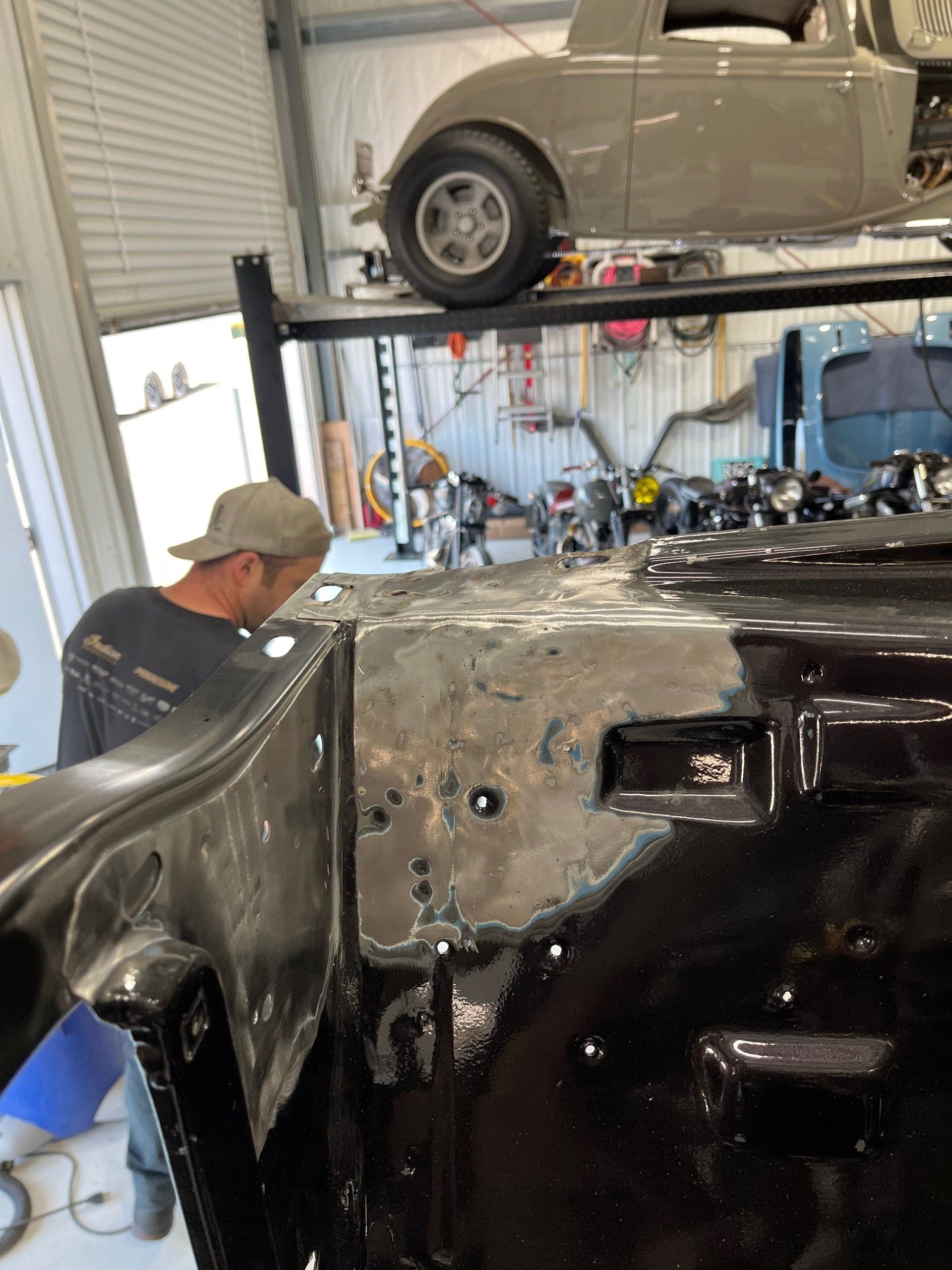 A man is working on a car in a garage.