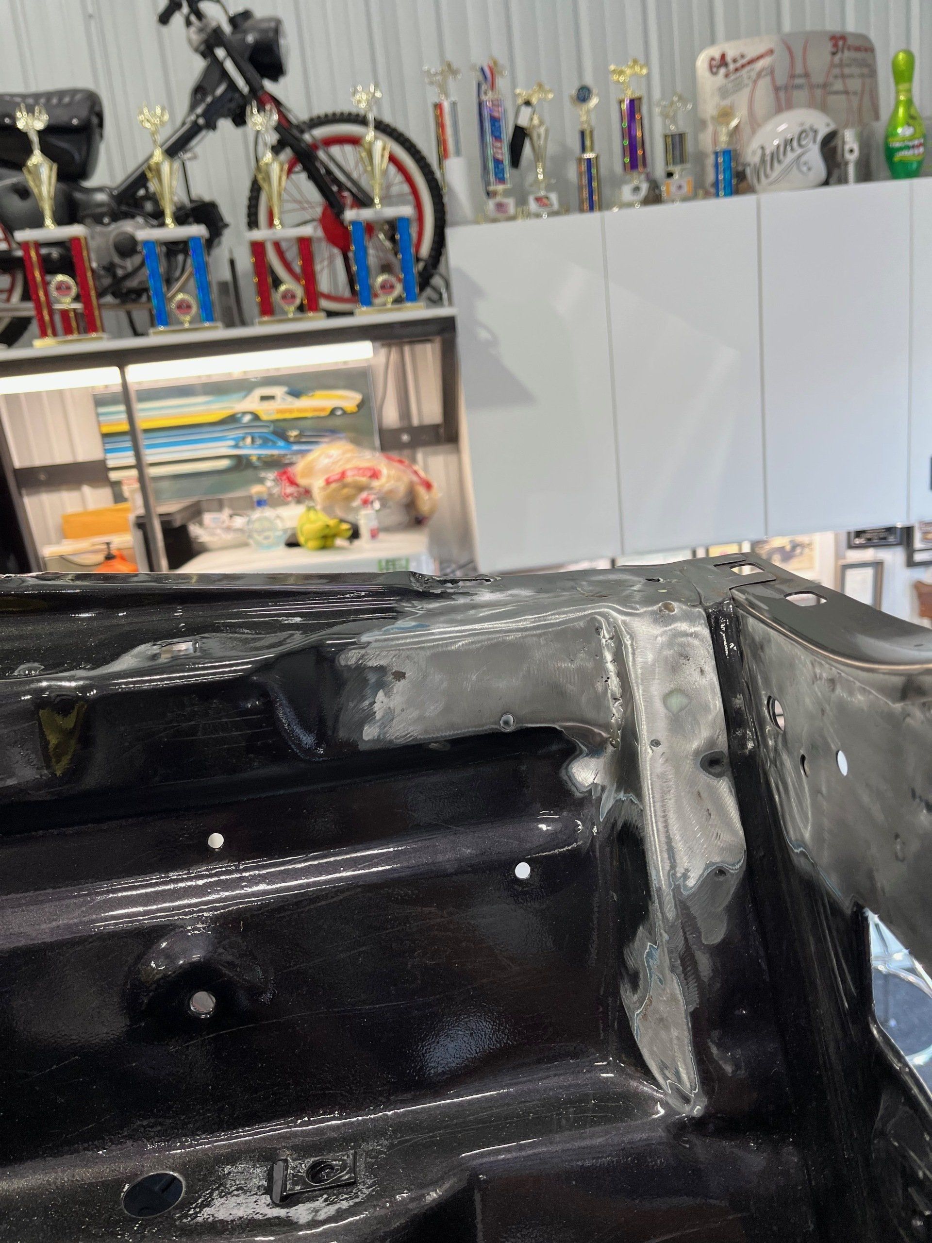 A bicycle is sitting on a shelf with trophies on it