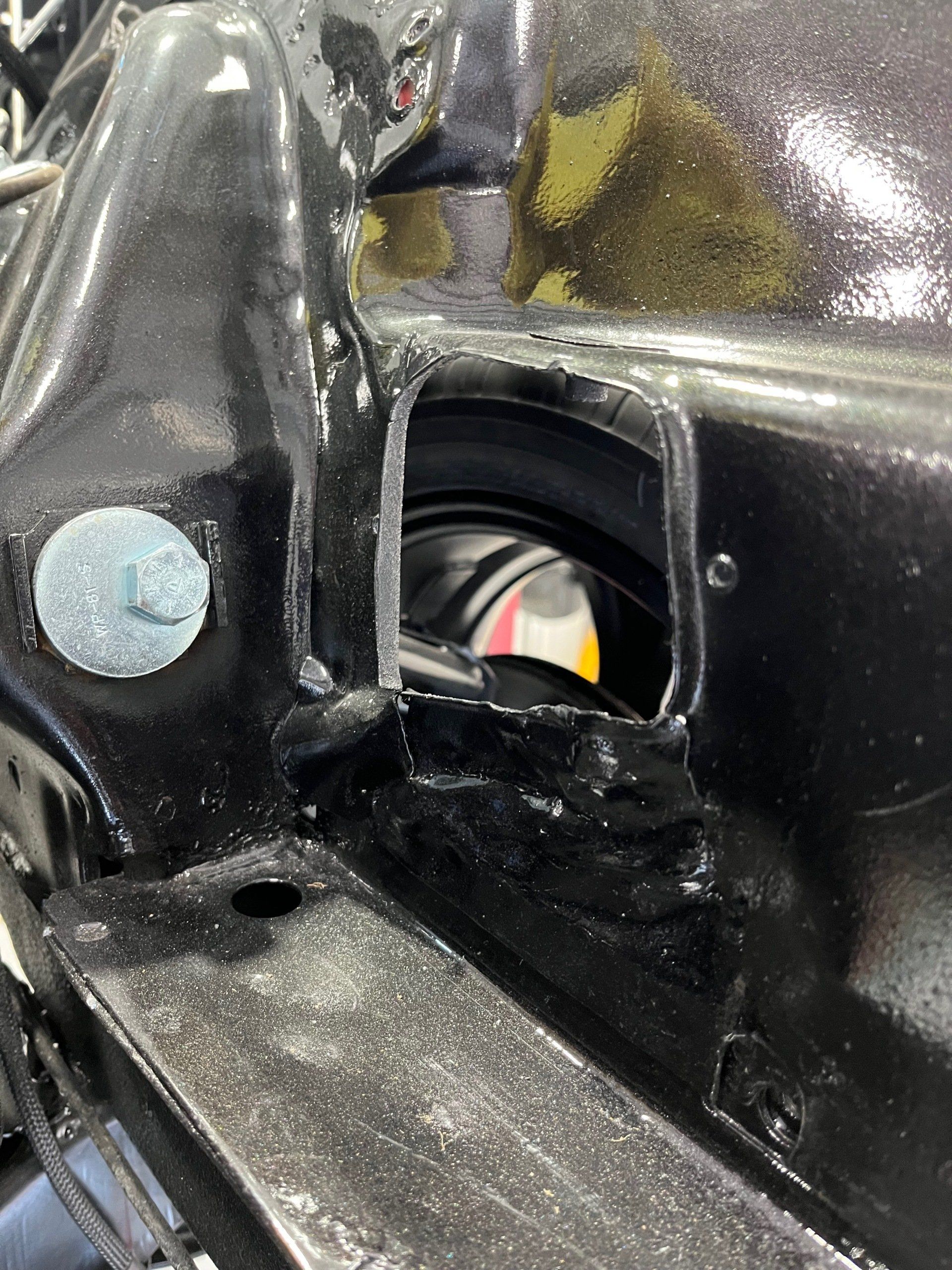 A close up of a black car with a hole in it.