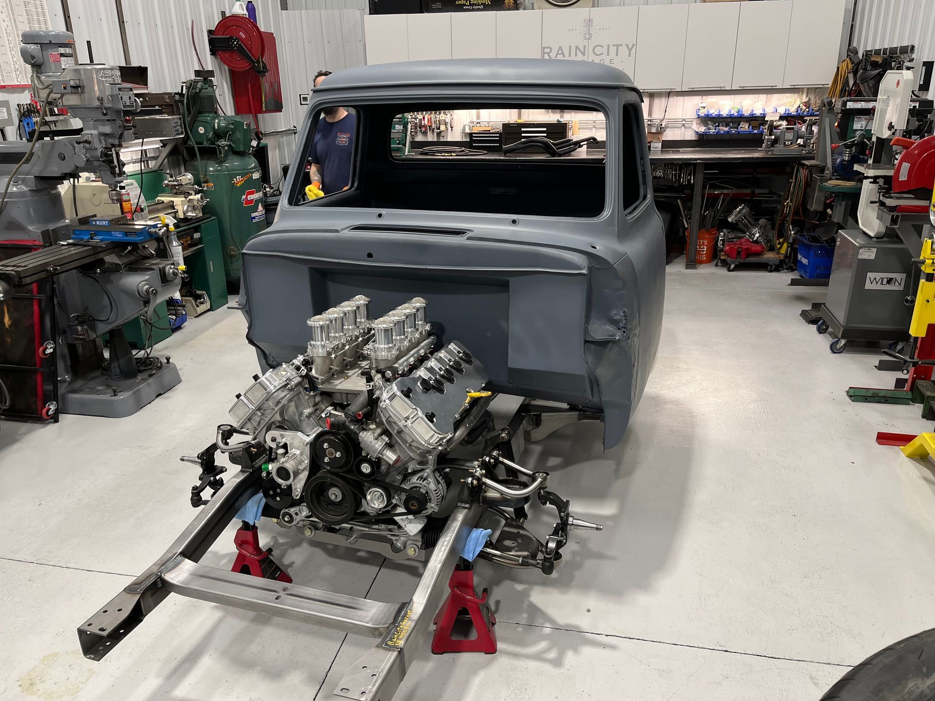 A truck with a v8 engine is being built in a garage.