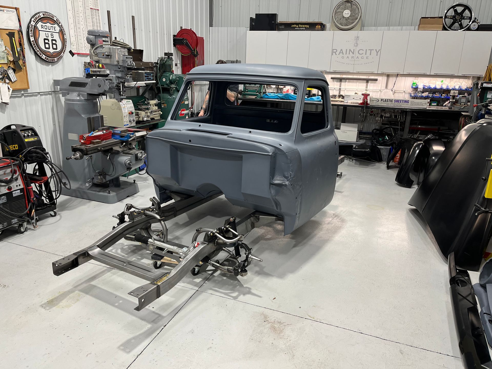 A truck is sitting on a lift in a garage.