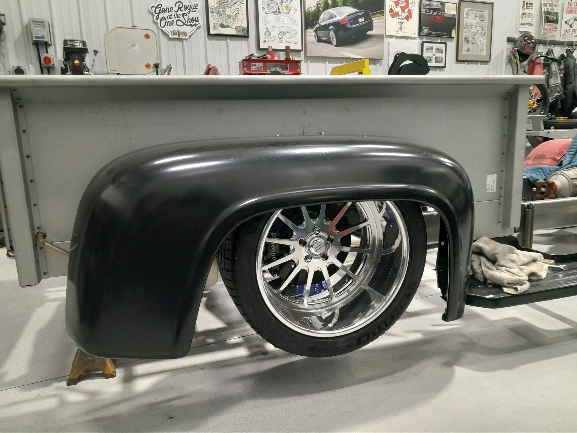 A car fender is sitting on top of a table in a garage.
