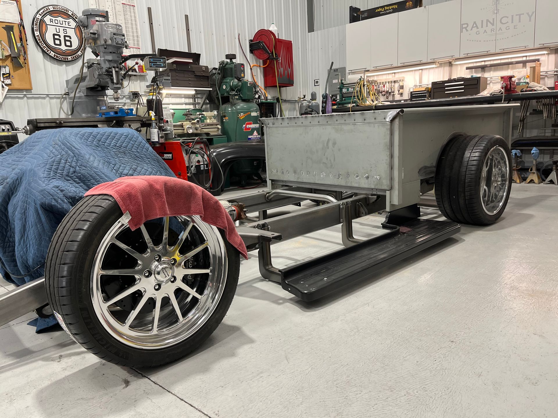 A car is being built in a garage with a trailer attached to it.