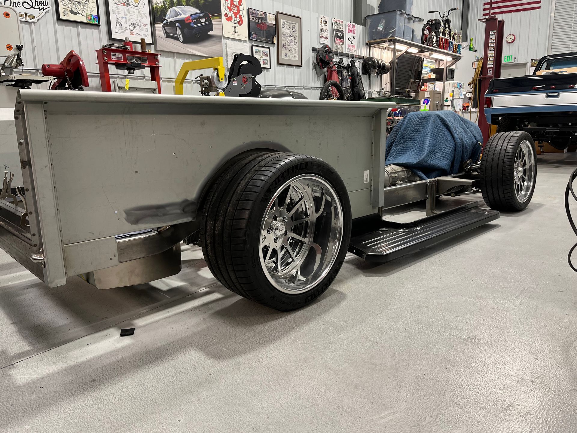 A car is being built in a garage with a trailer attached to it.
