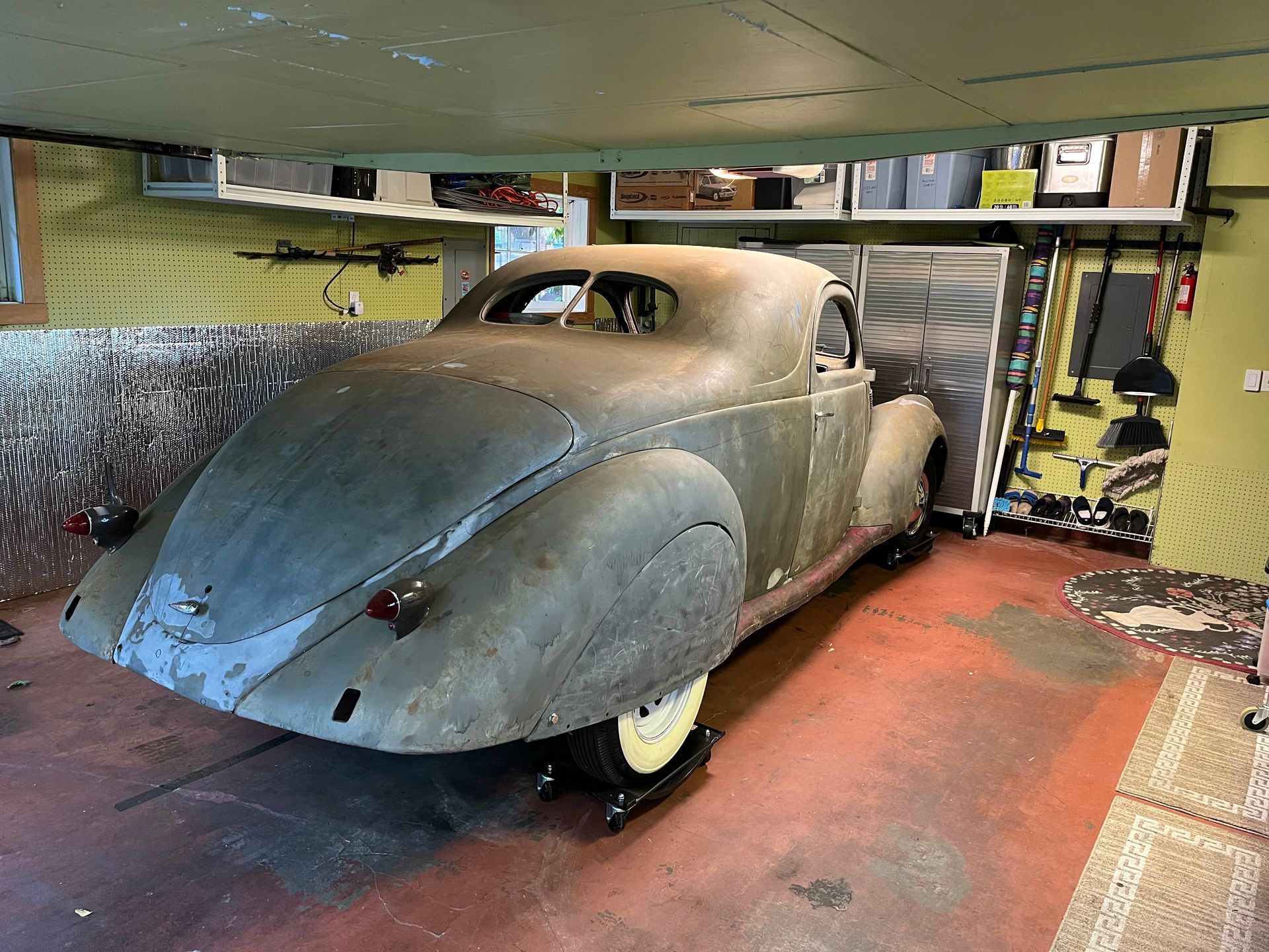 An old car is parked in a garage.