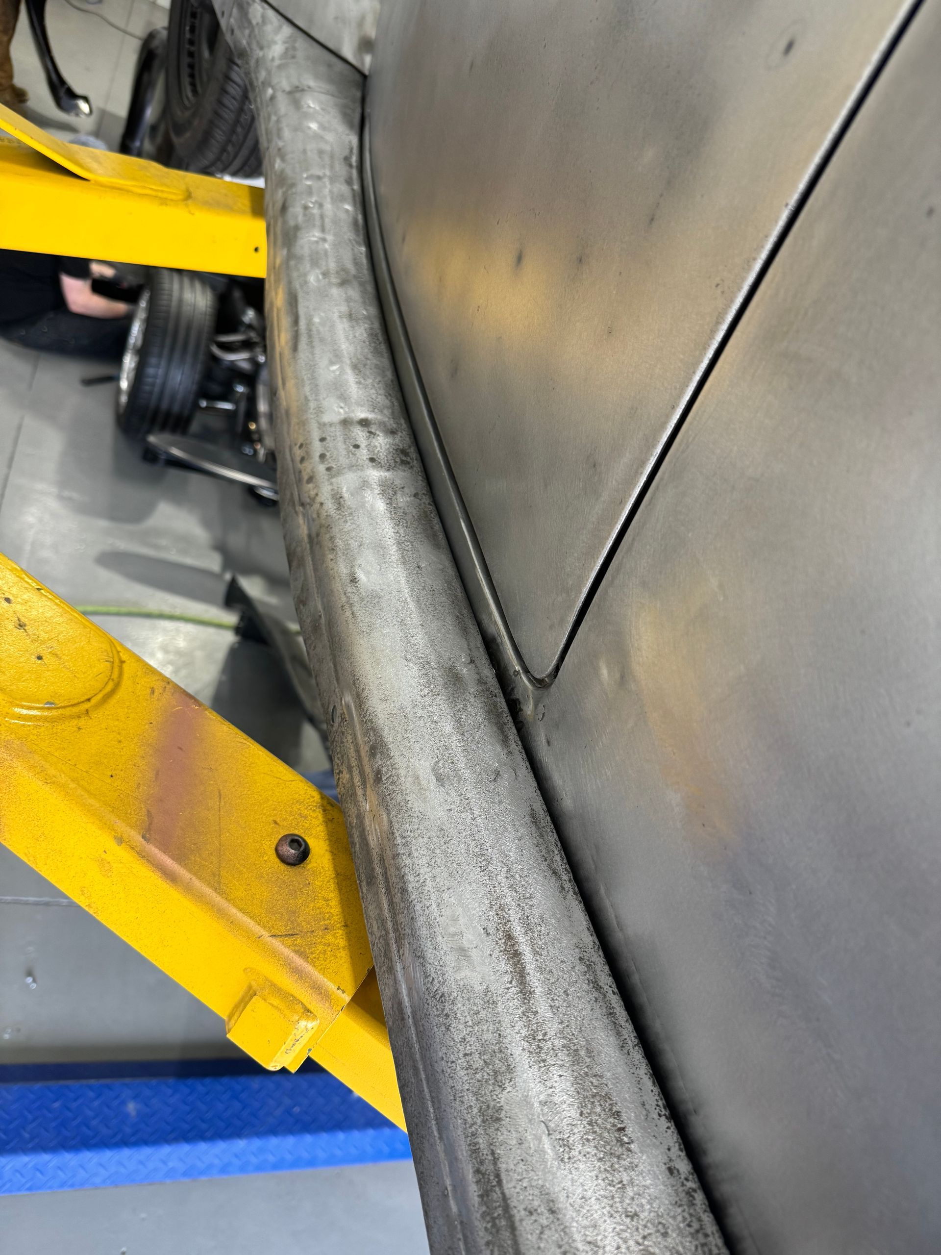 A close up of a car on a lift in a garage.