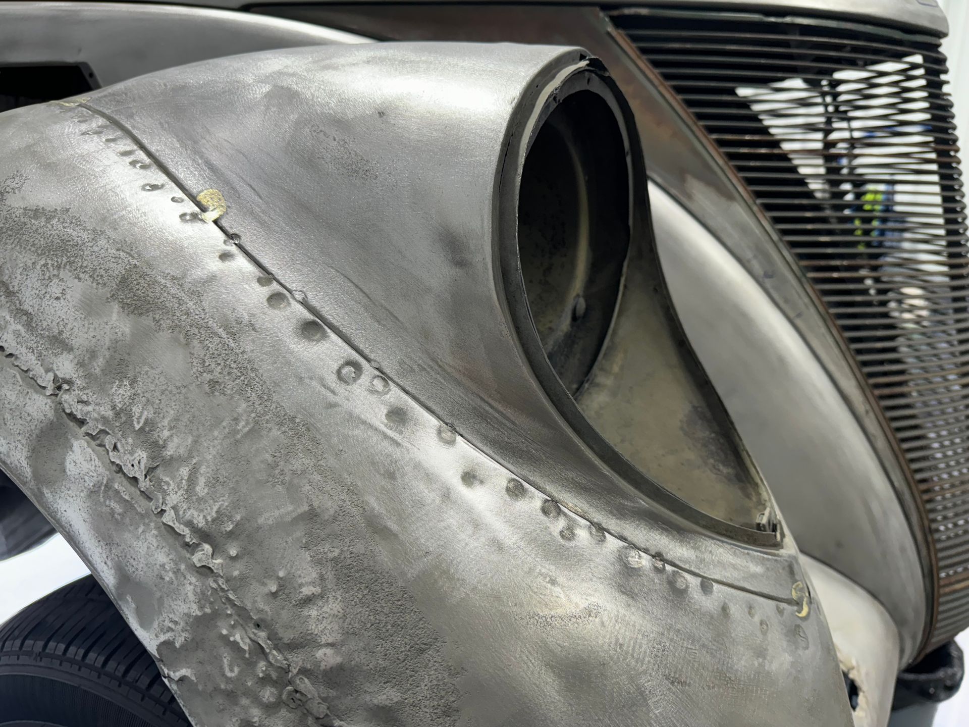 A close up of a car 's fender with rivets on it