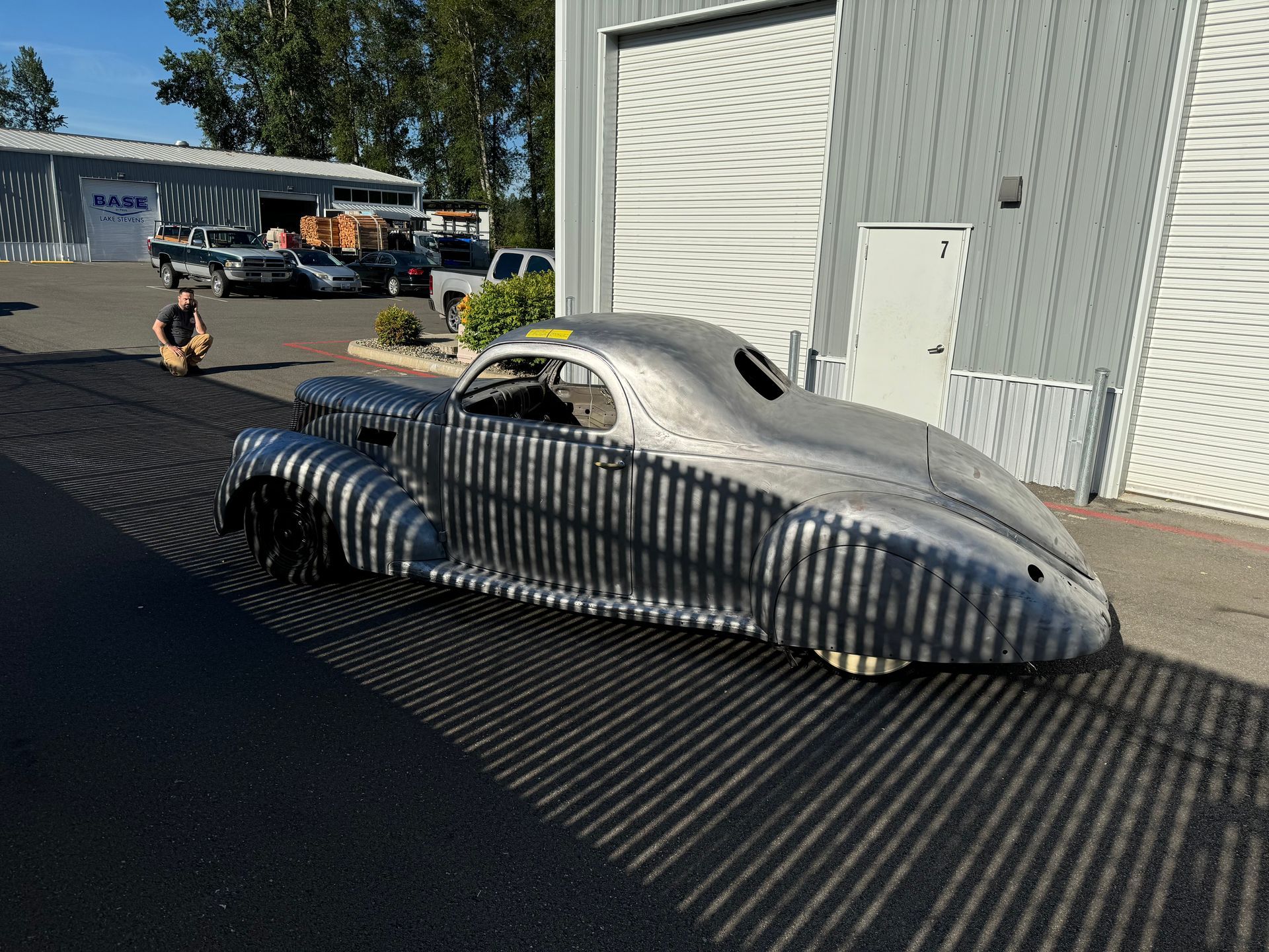A silver car is parked in front of a building.
