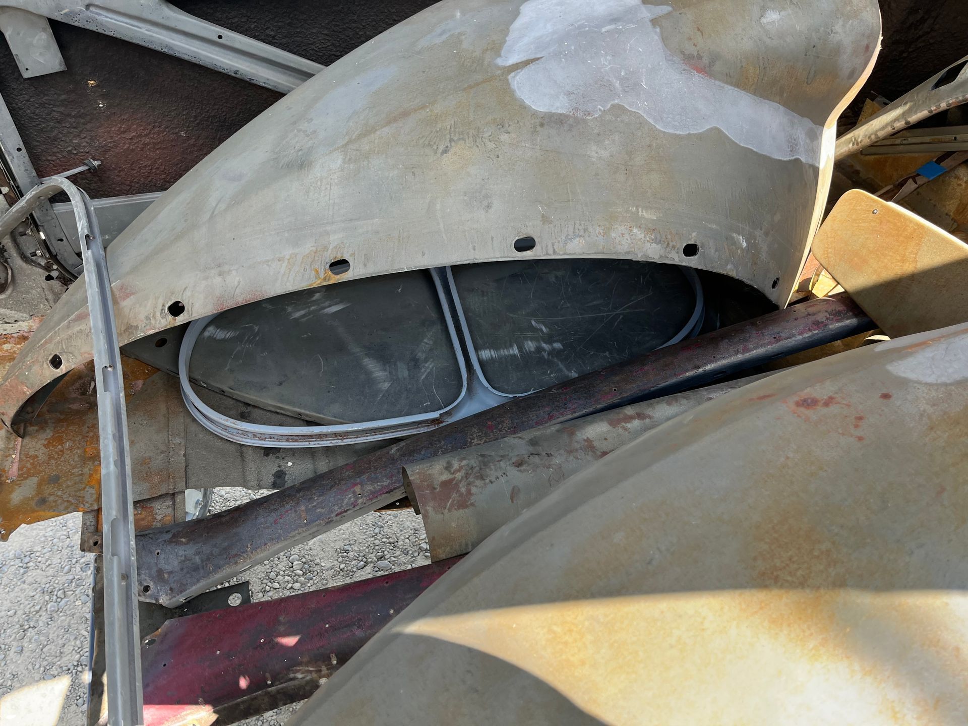 A bunch of old car parts are sitting on the ground.