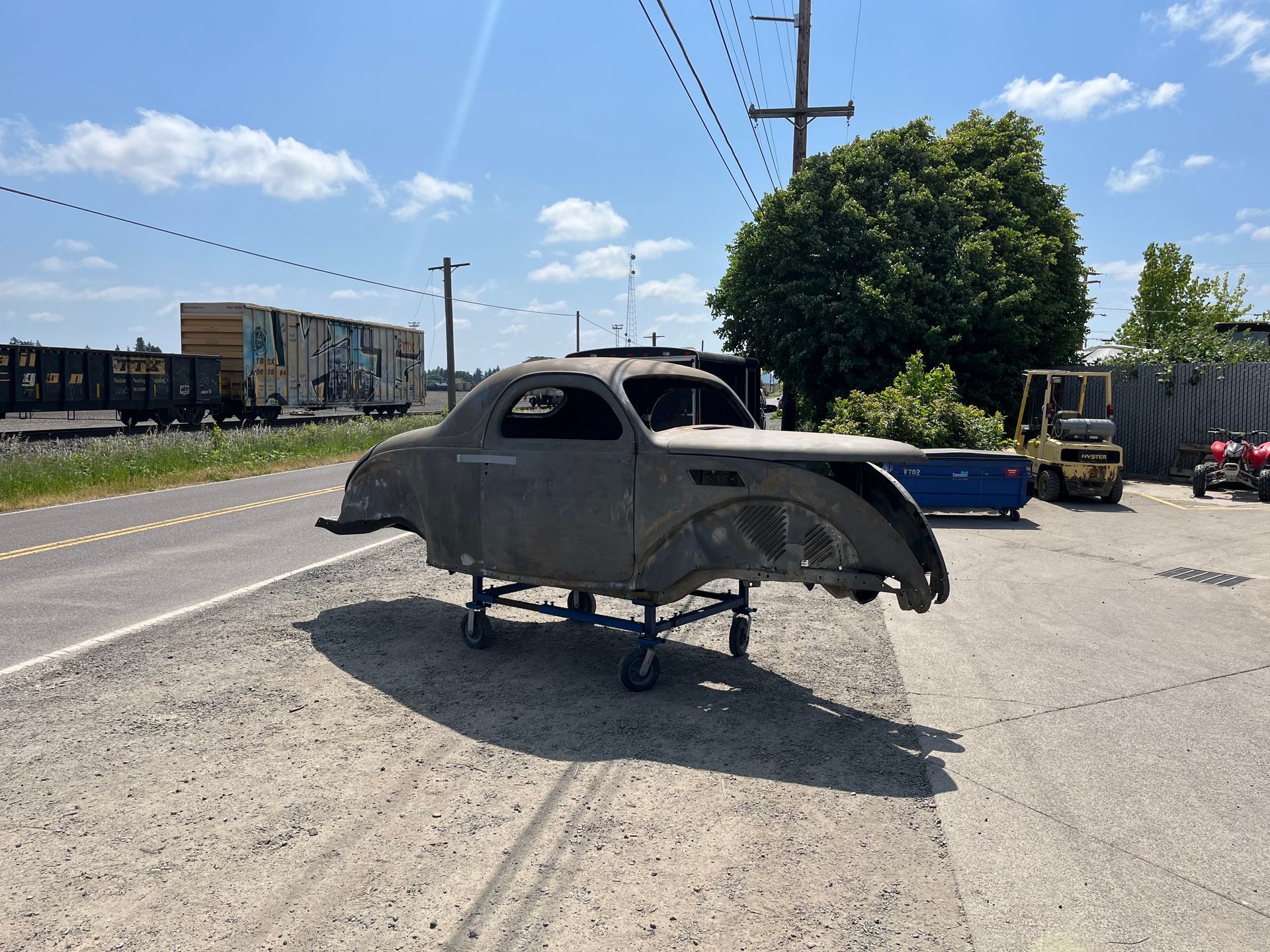A car is sitting on a cart on the side of the road.