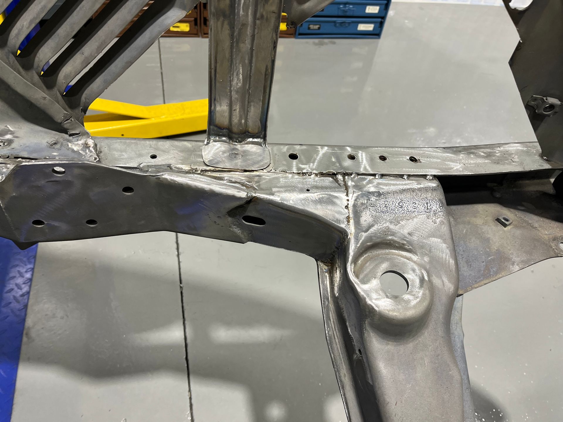 A metal frame is sitting on a concrete floor in a garage.