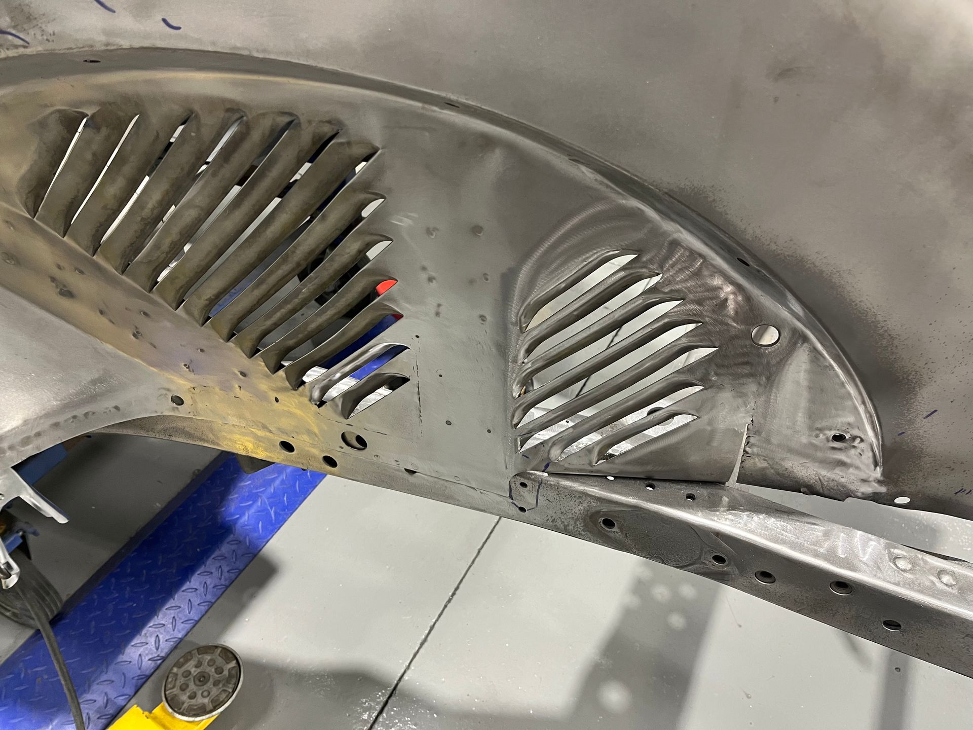 A close up of a car fender with a grille on it.
