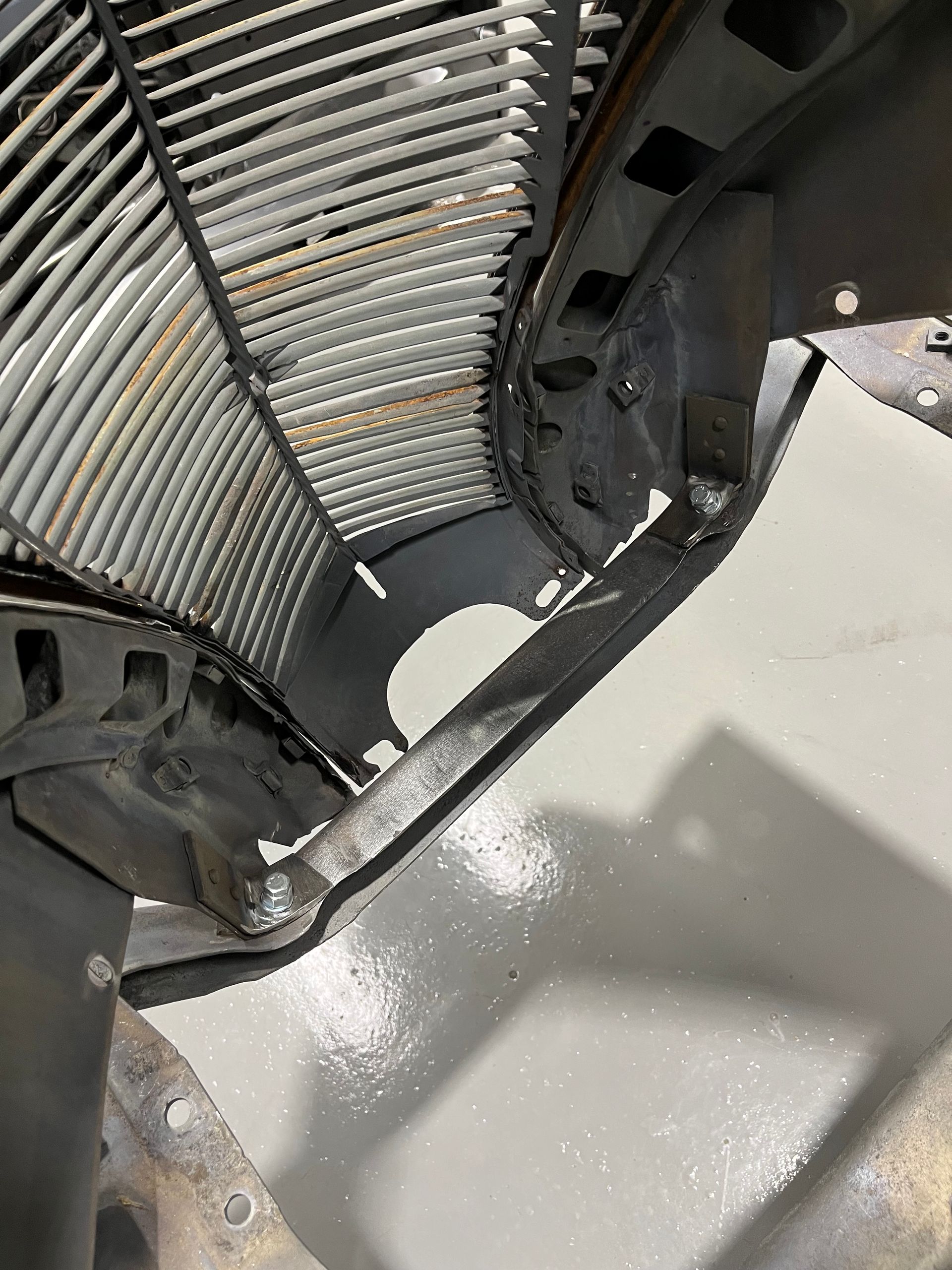 A close up of a radiator on a car in a garage.