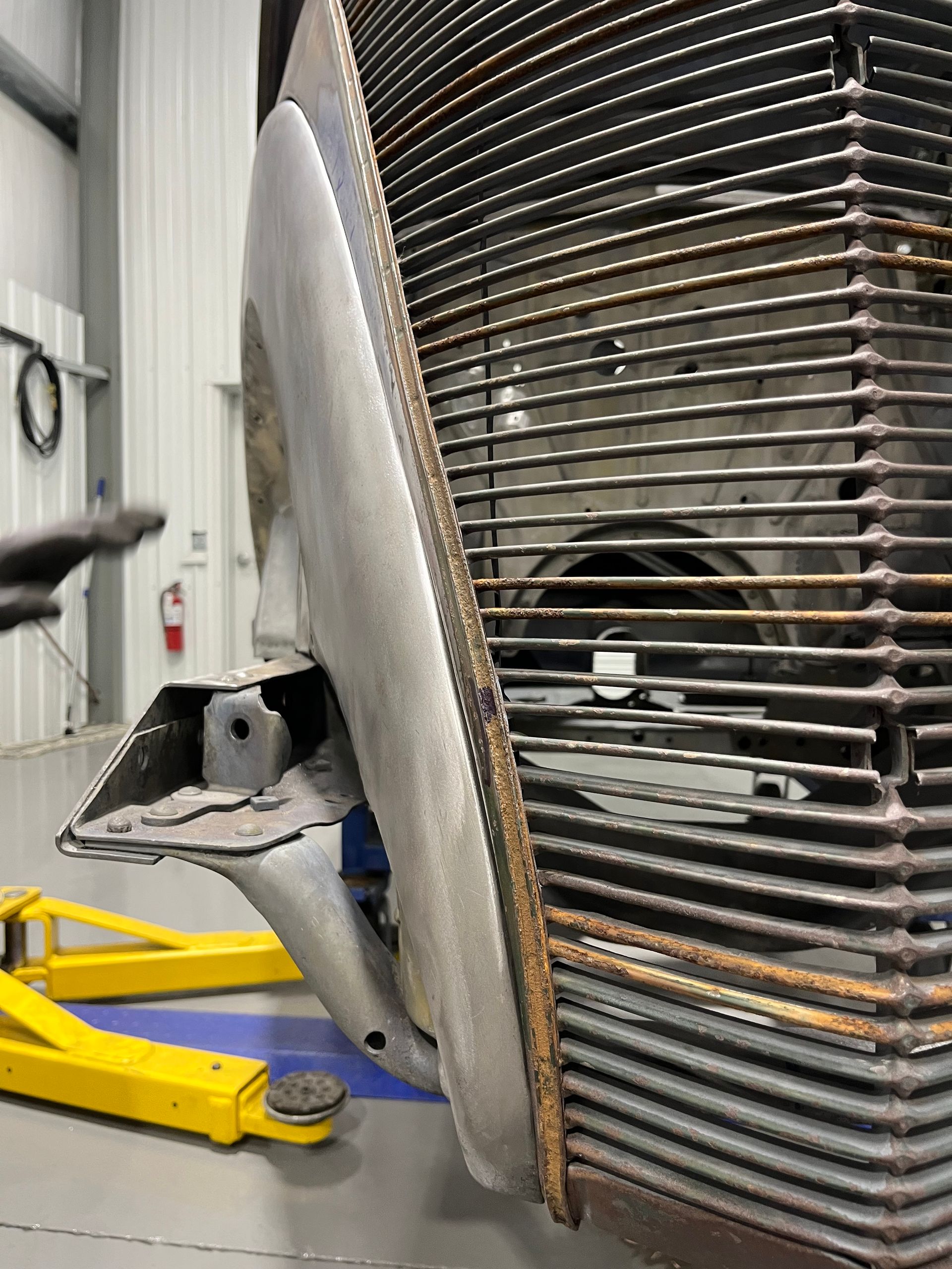 A car is sitting on a lift in a garage.