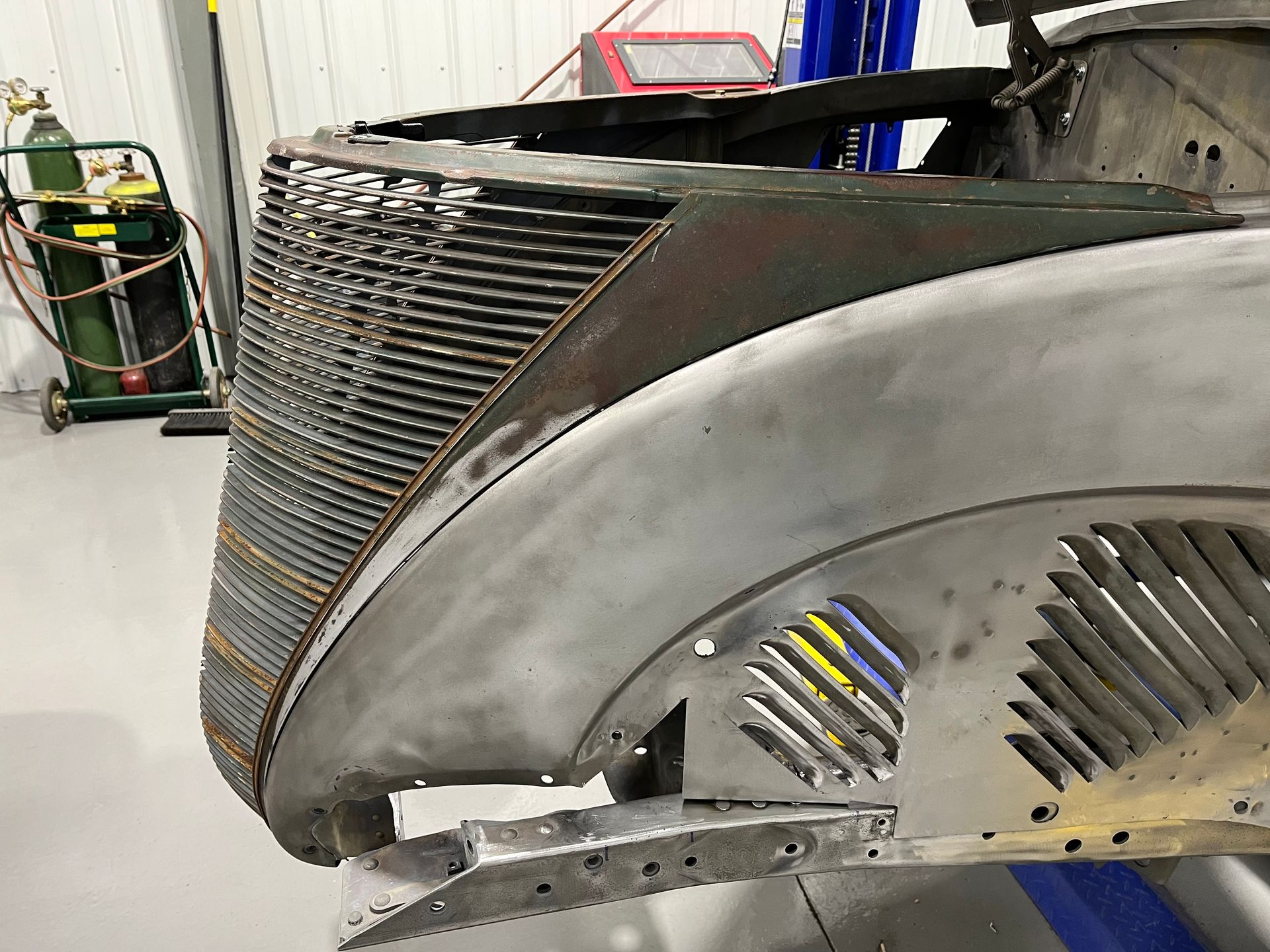 A close up of a car grill in a garage.