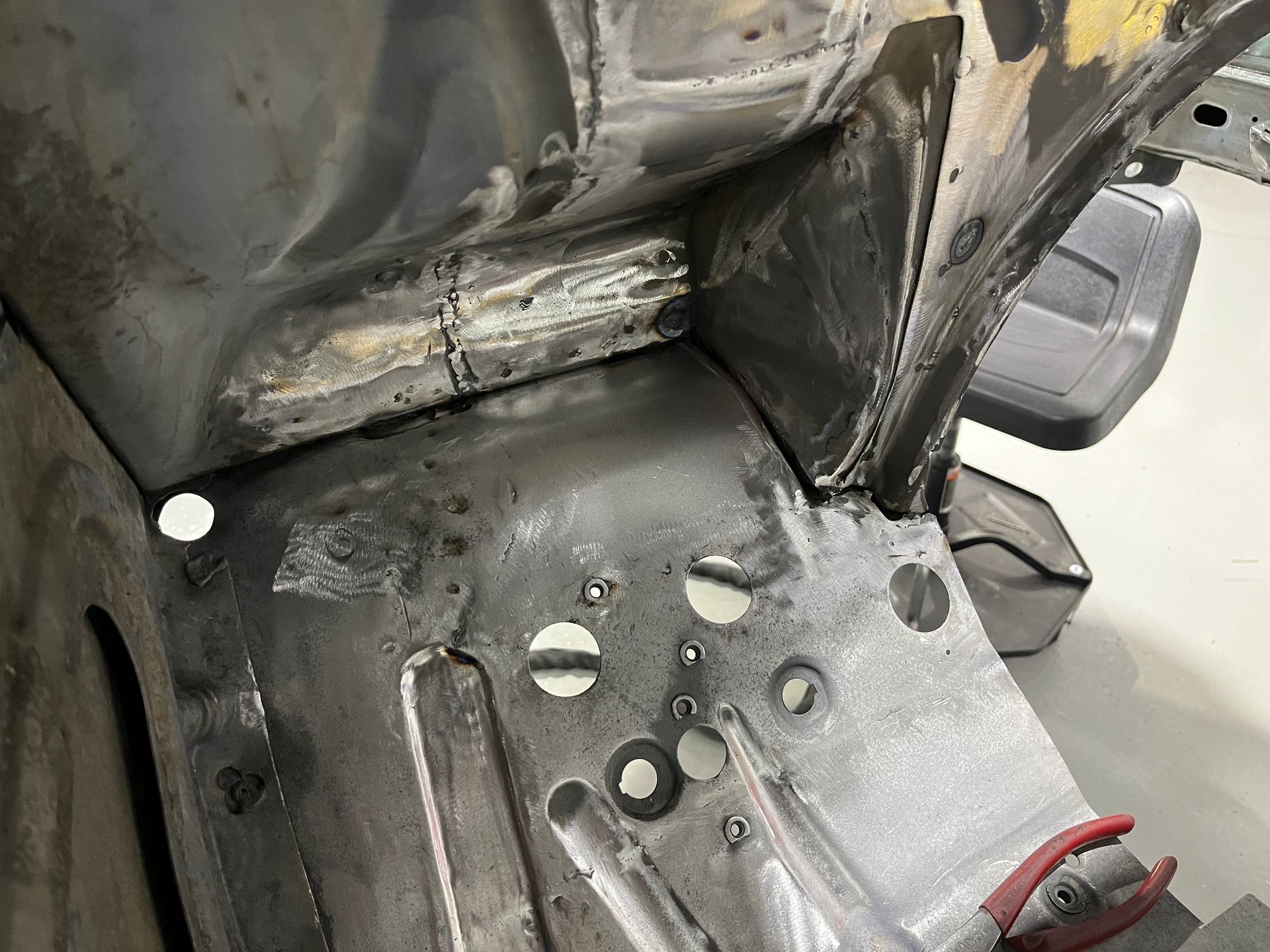 A close up of a piece of metal with a pair of pliers on it.