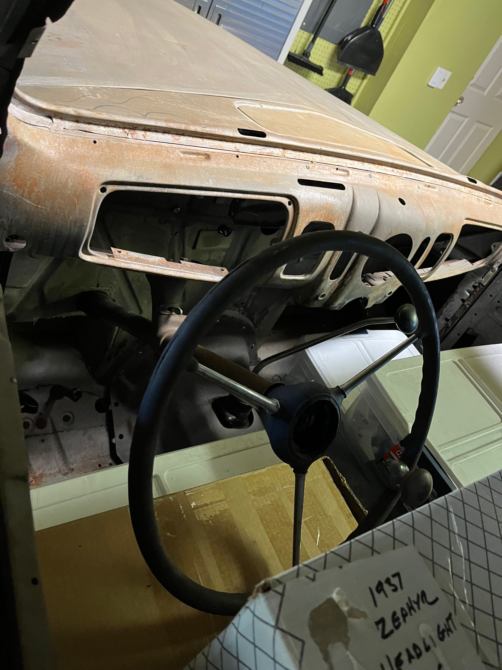 A steering wheel in a car with a sign that says 1957