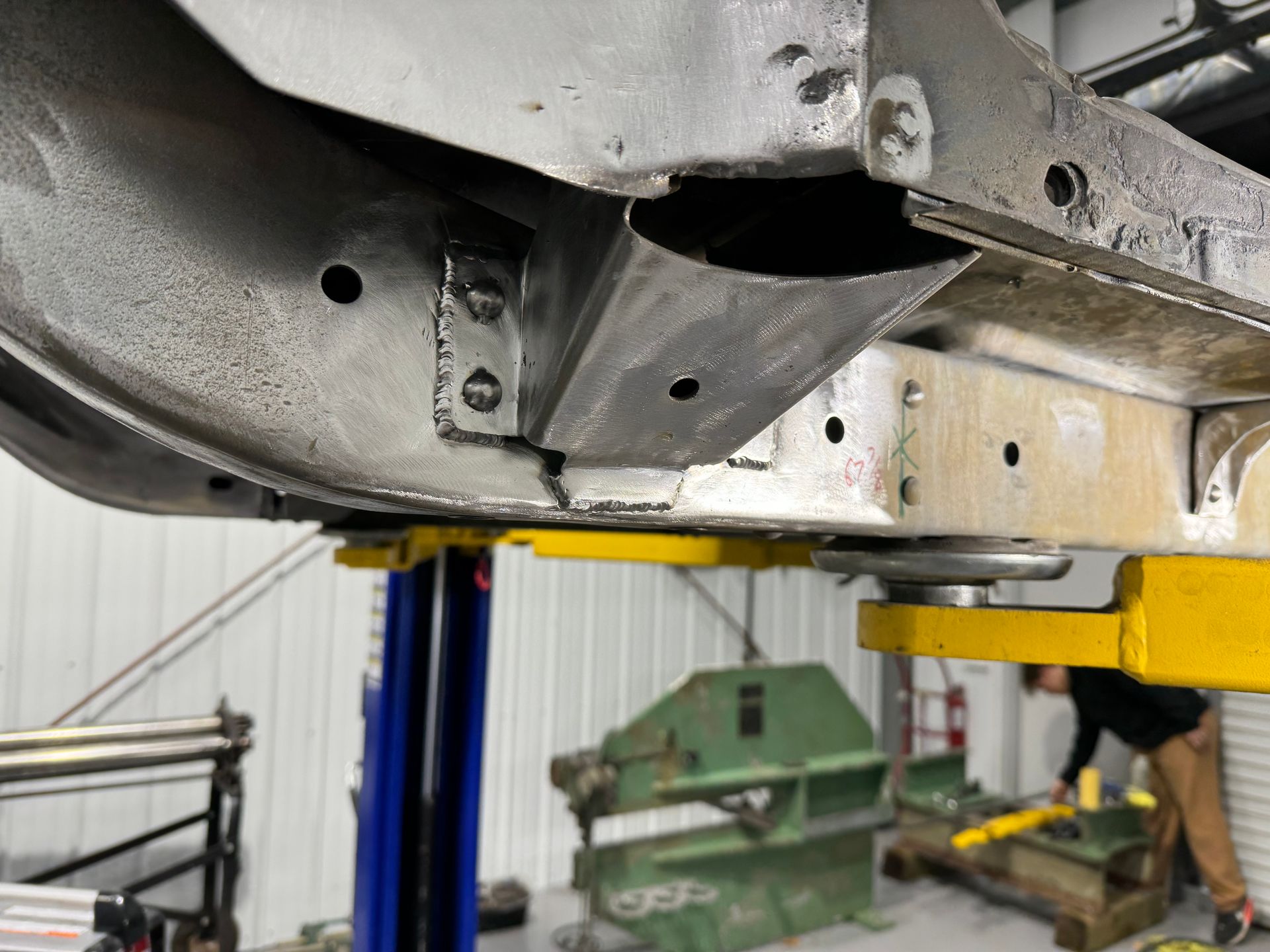 A car is sitting on a lift in a garage.