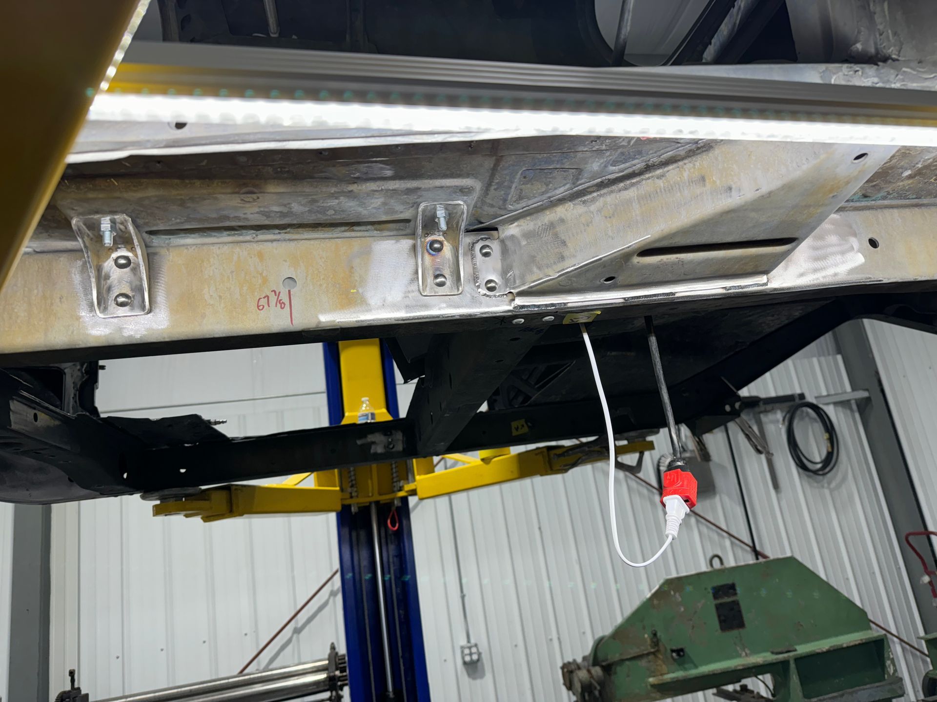 A car is sitting on a lift in a garage.