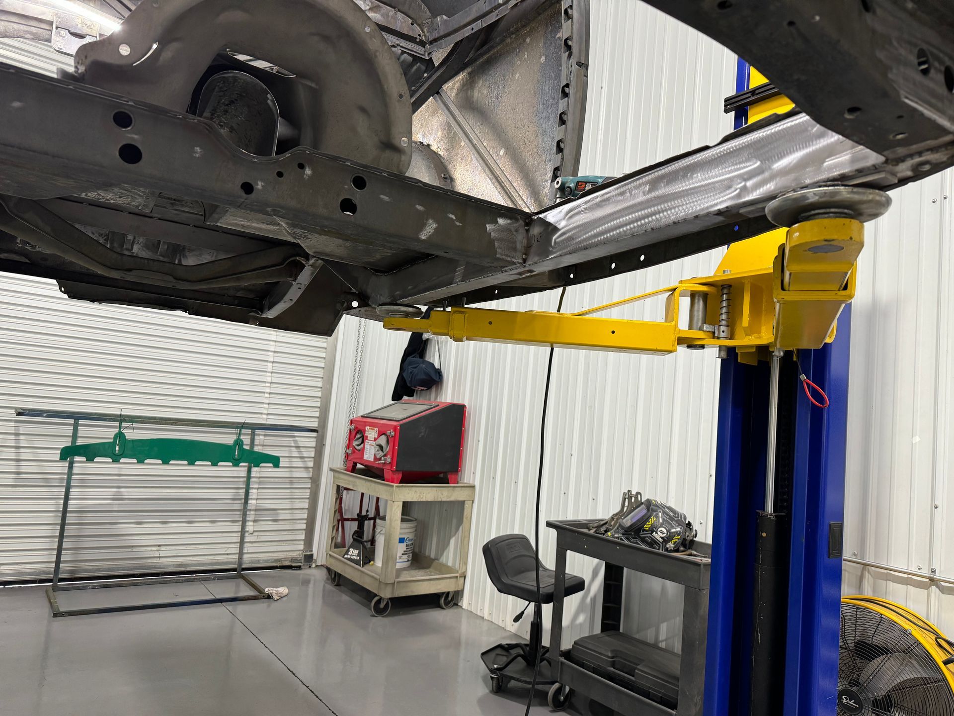 A car is sitting on a lift in a garage.