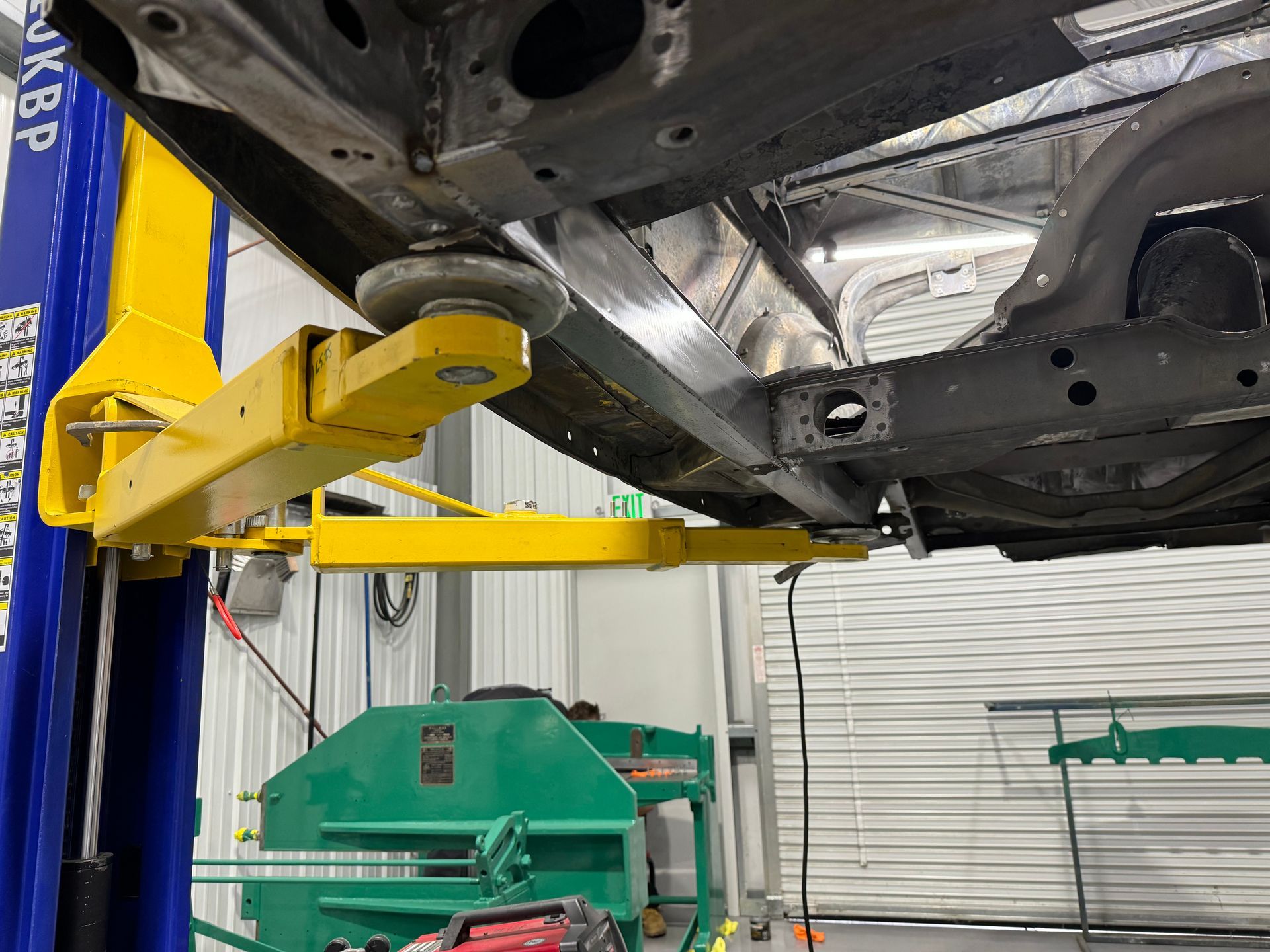 A car is sitting on a lift in a garage.