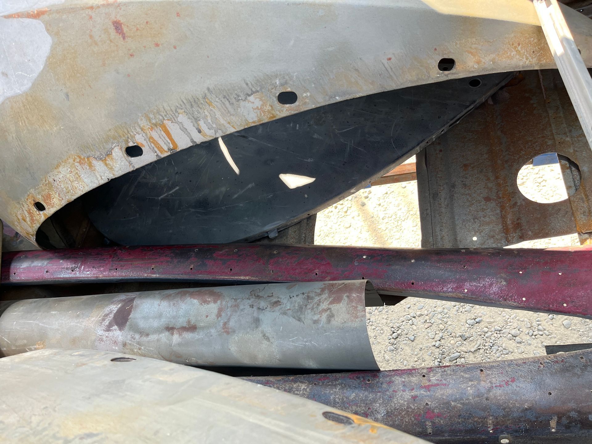 A close up of a rusty metal fender on a car.