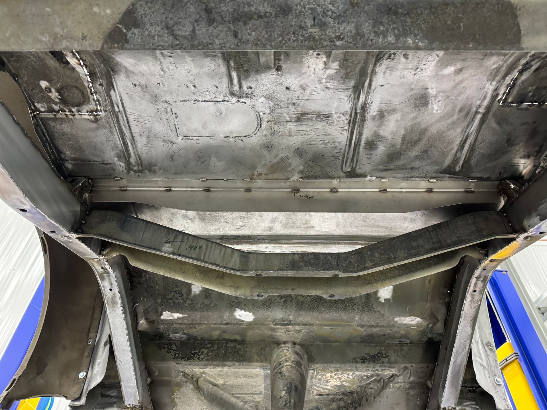 A close up of the bottom of a car on a lift.