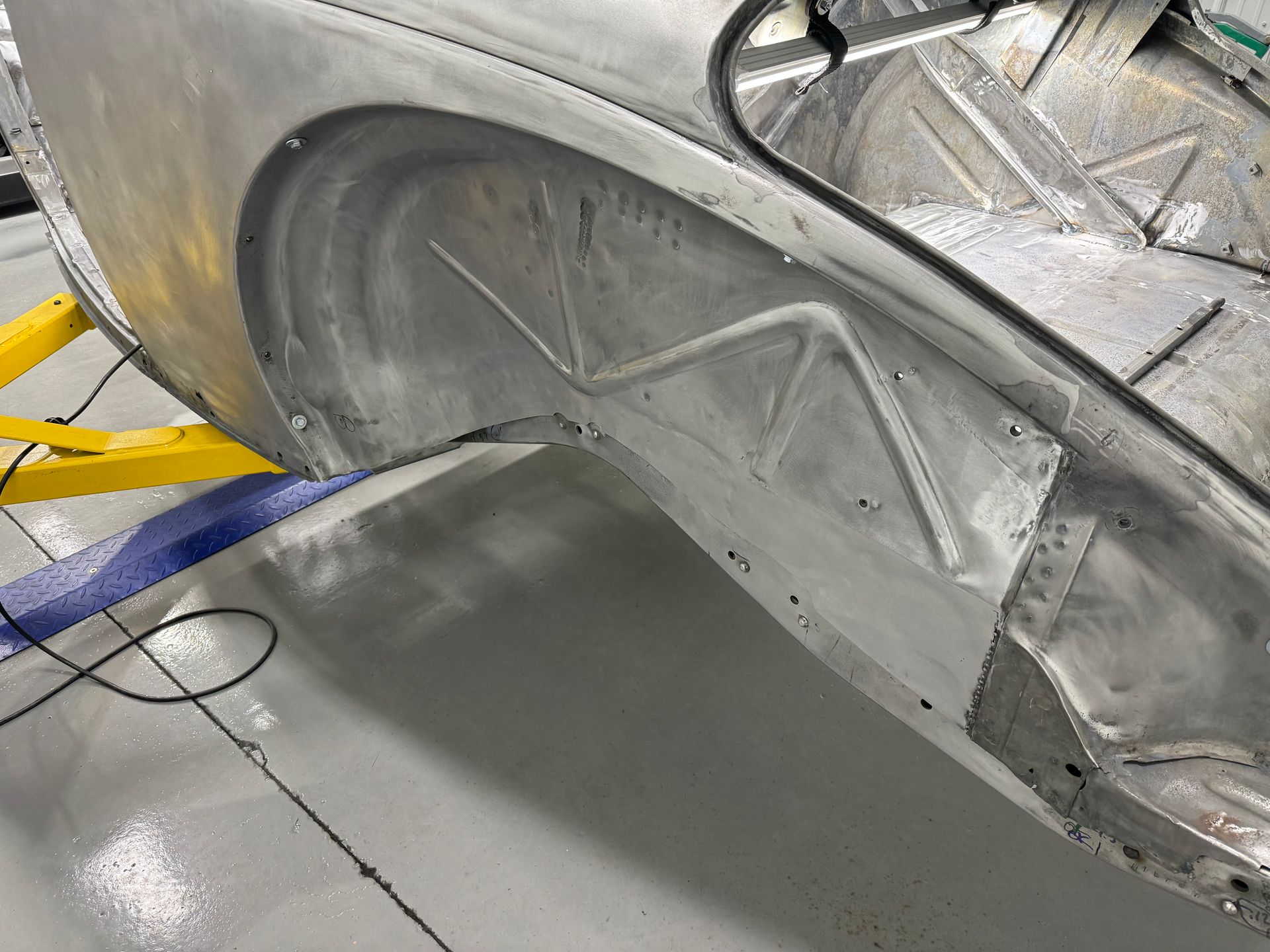 A car is sitting on a lift in a garage.