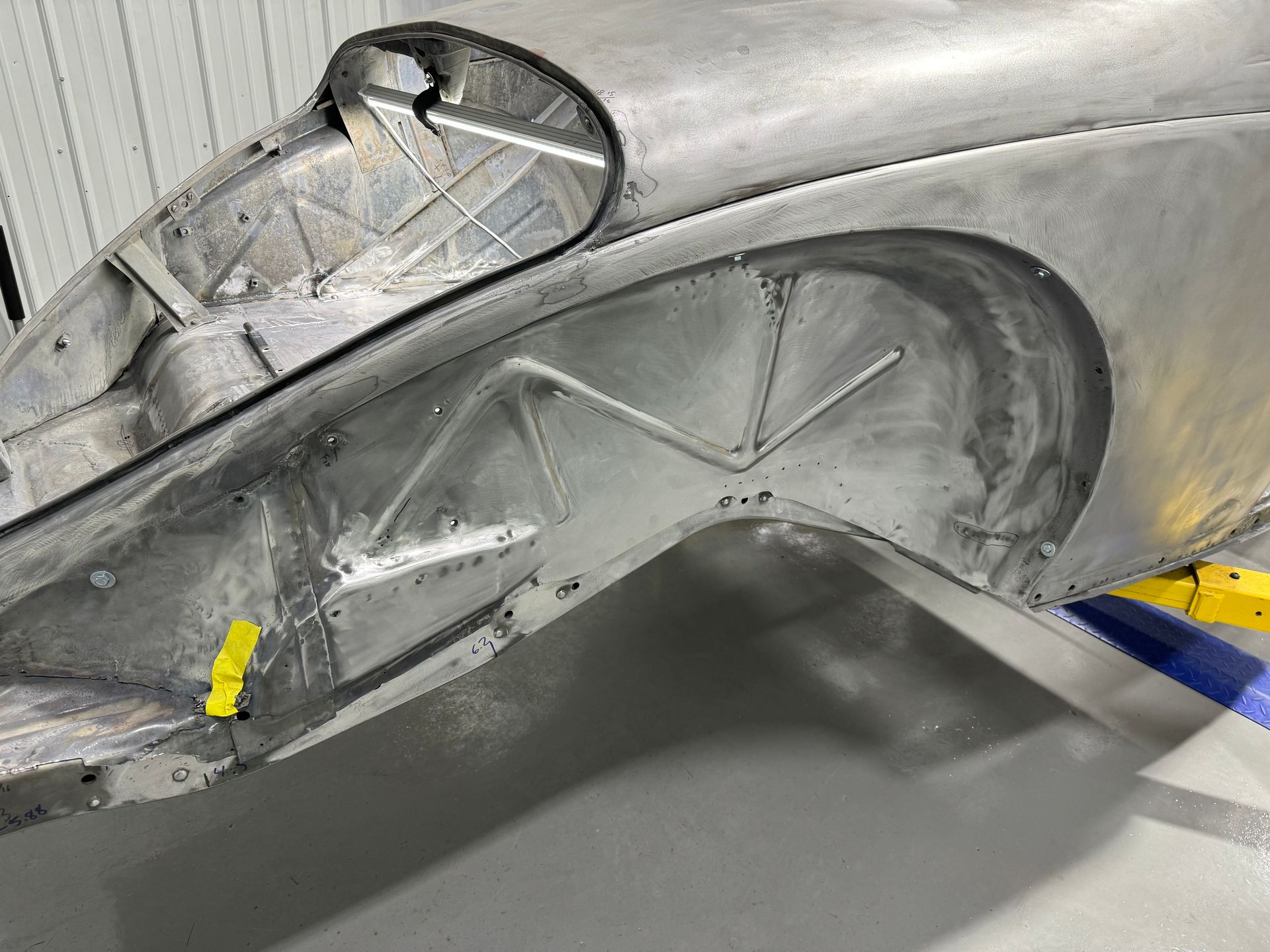 A close up of a car fender in a garage.