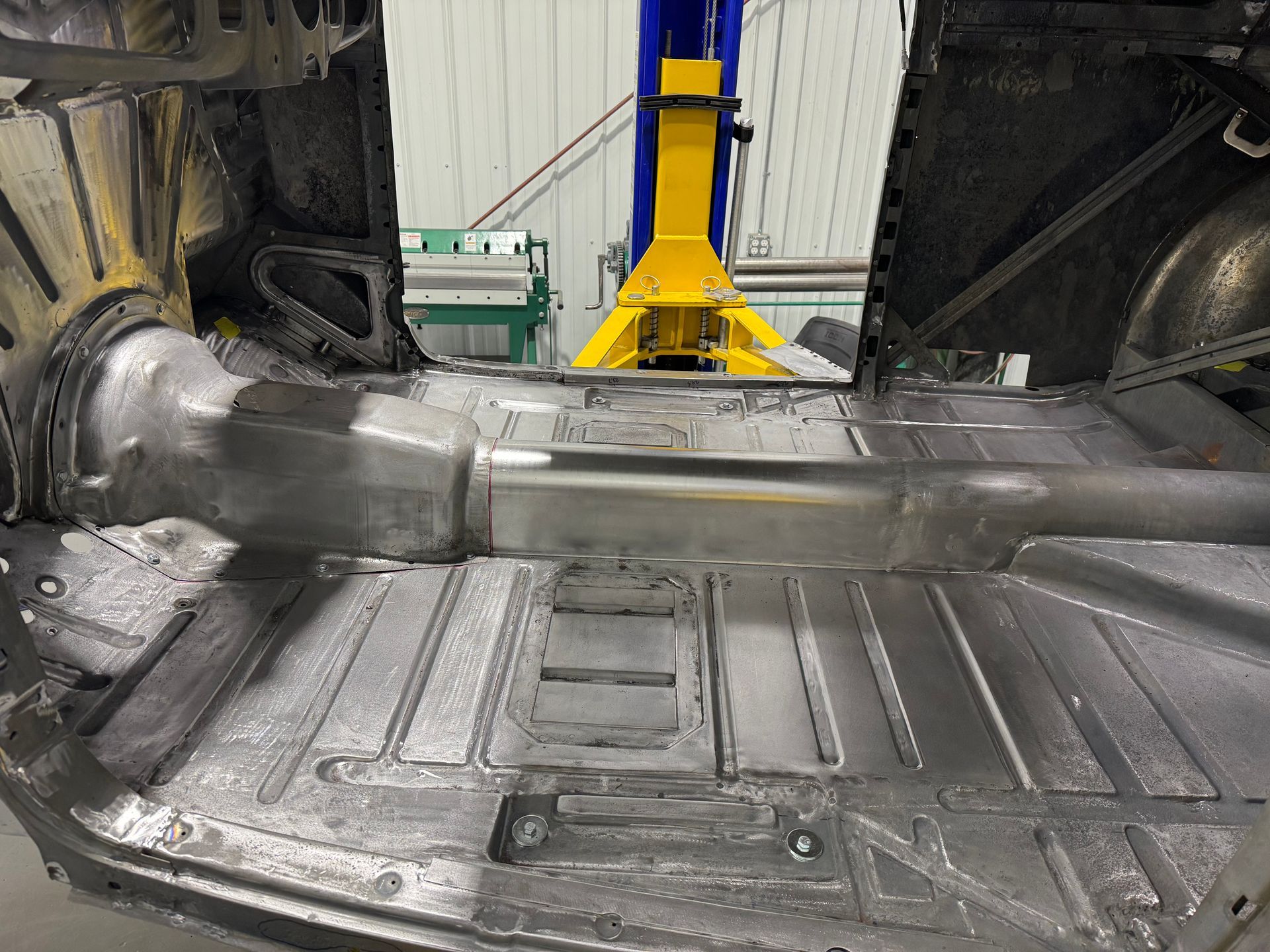 A car is sitting on a lift in a garage.