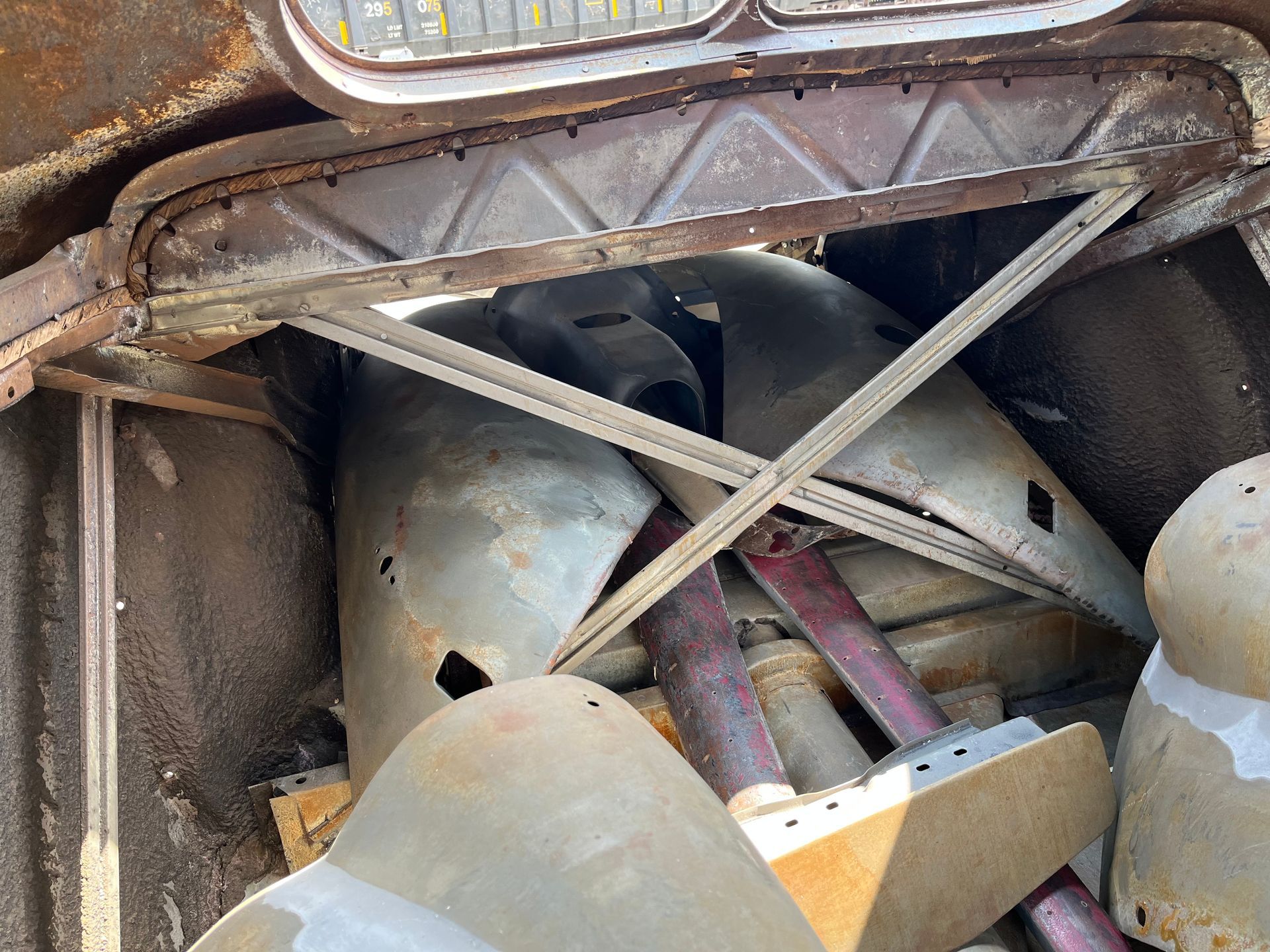 A pile of old car parts are stacked on top of each other.