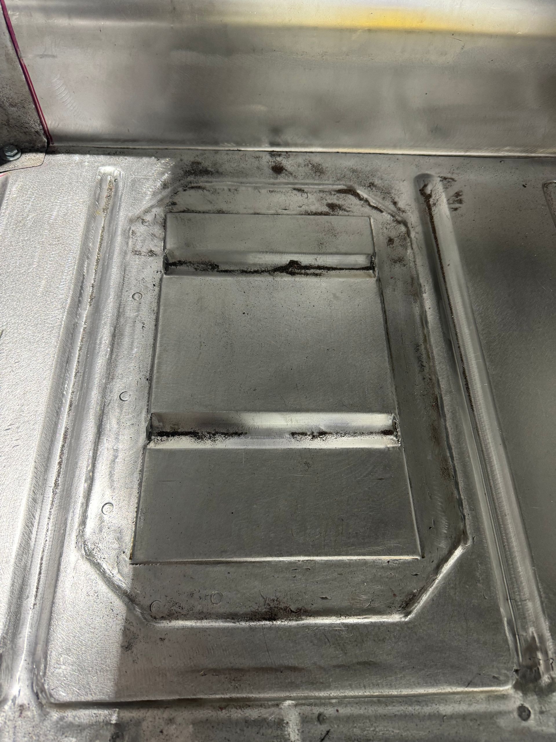 A close up of a metal surface with a hole in it.