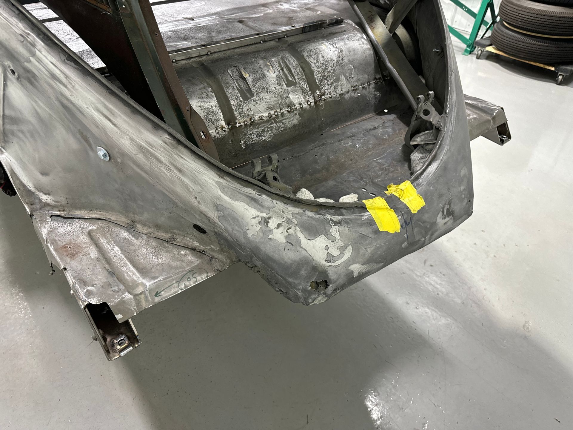 A car is sitting on a cement floor in a garage.