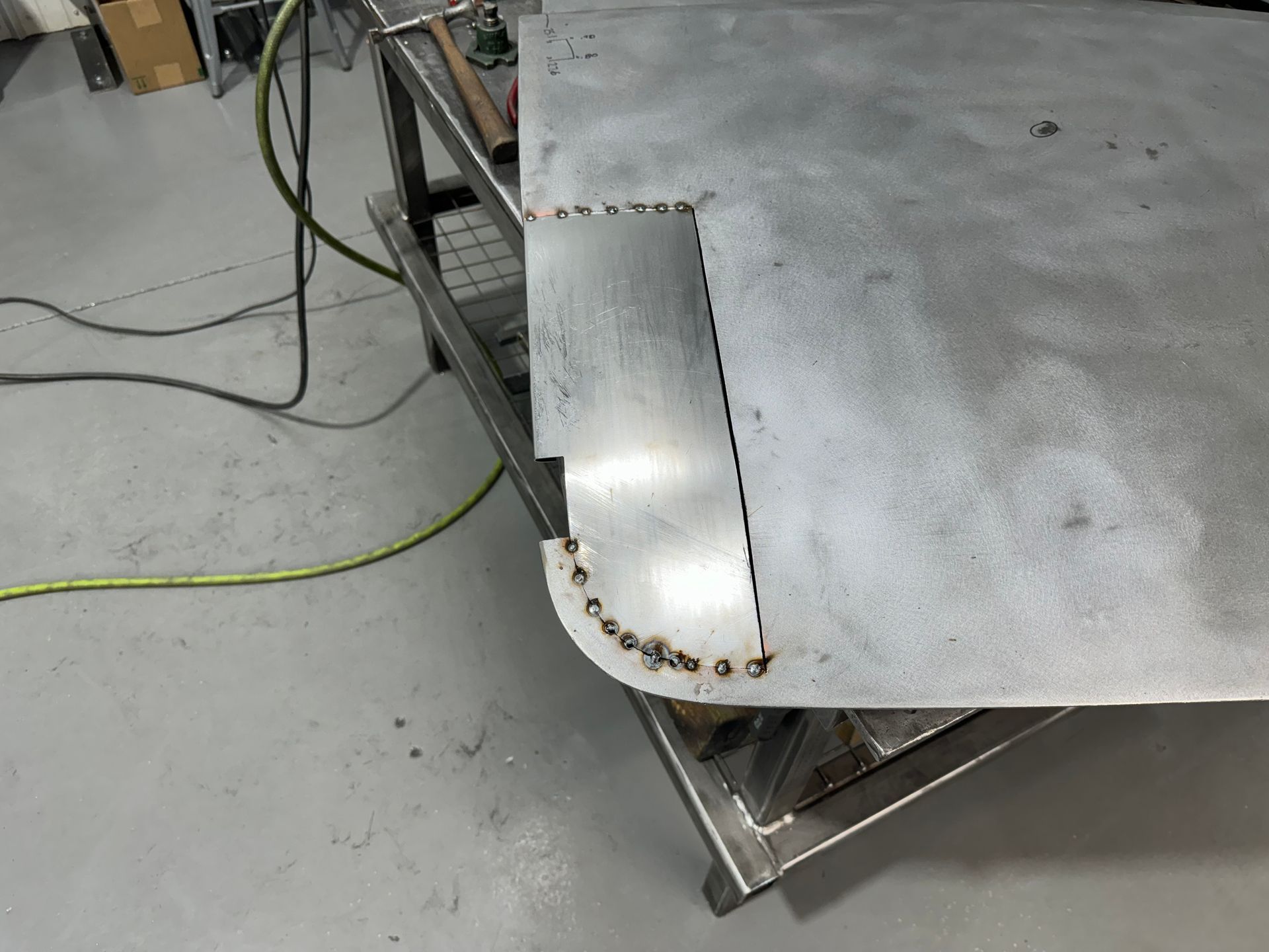 A piece of metal is sitting on top of a metal table.