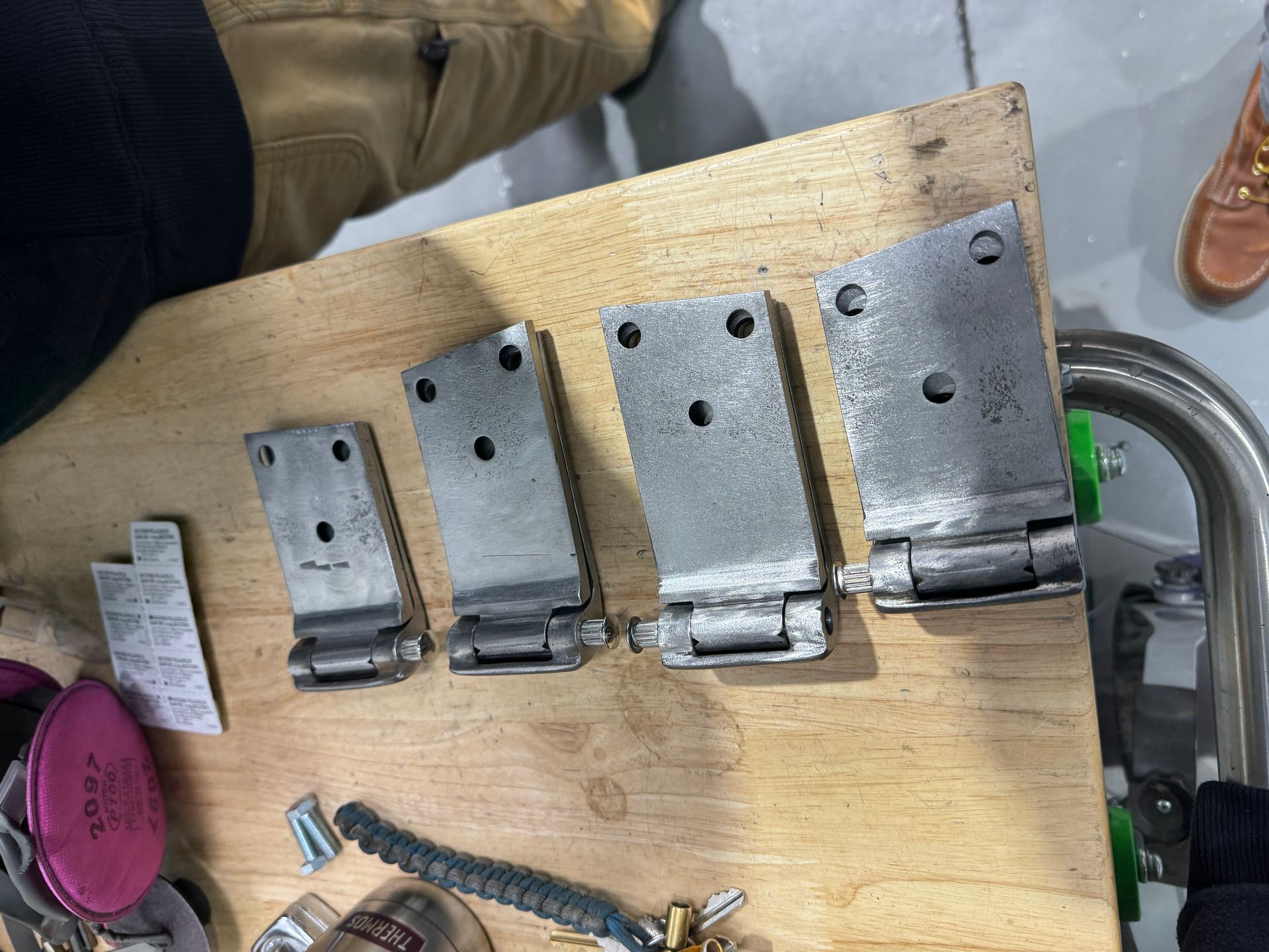 A wooden table with a bunch of metal pieces on it