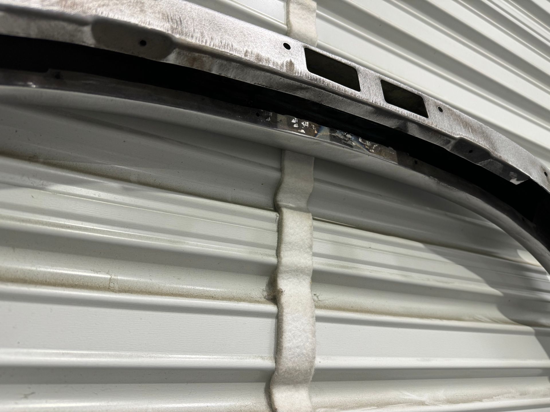 A close up of a piece of metal on a white wall.