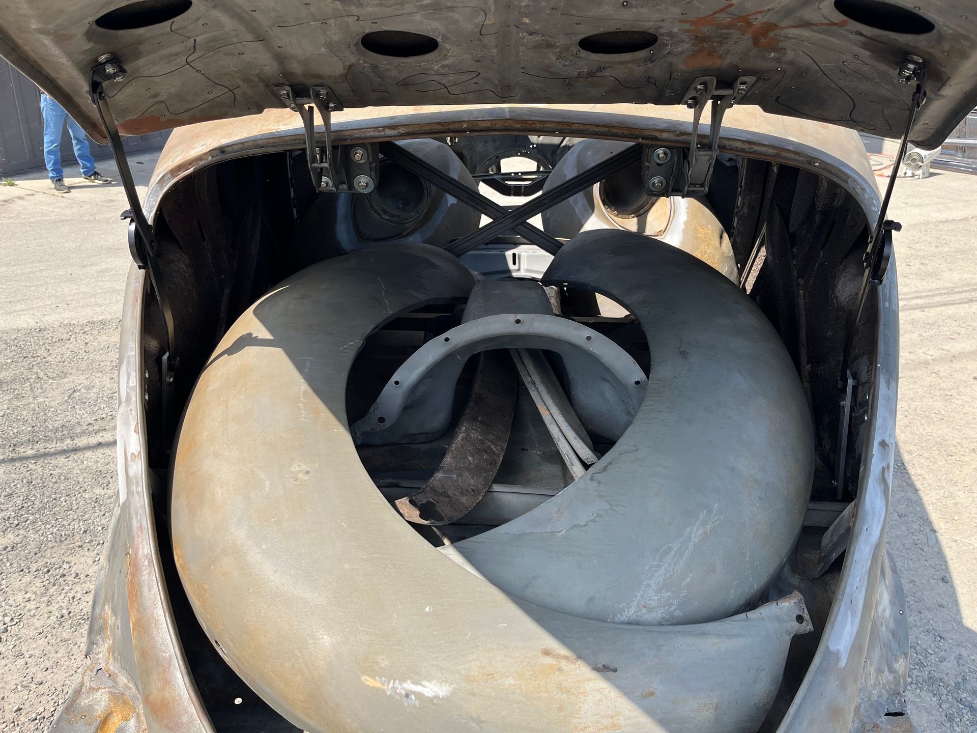 The trunk of a car with a tire in it