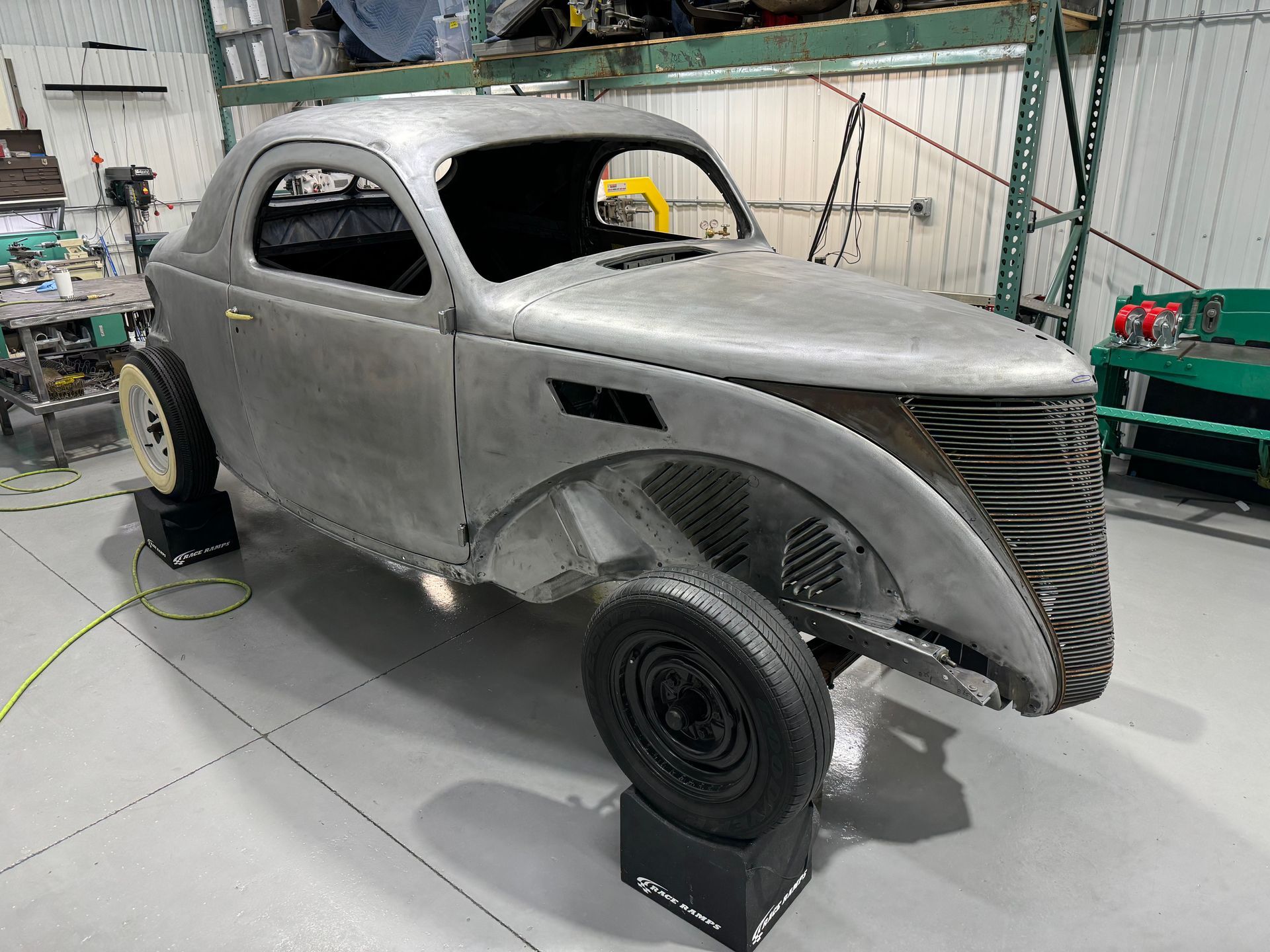 A car is sitting on a wheel in a garage.