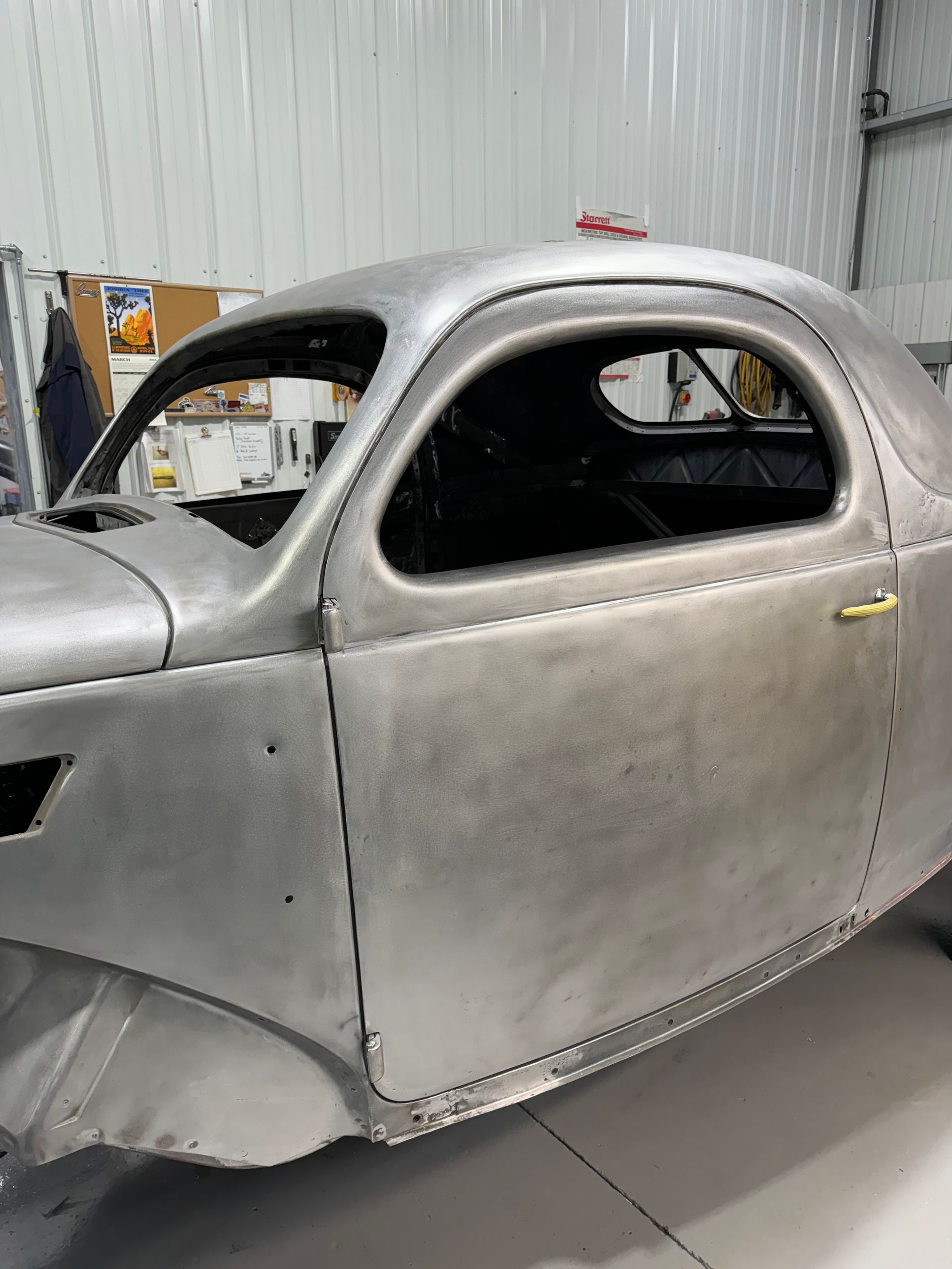 A silver car is sitting in a garage.
