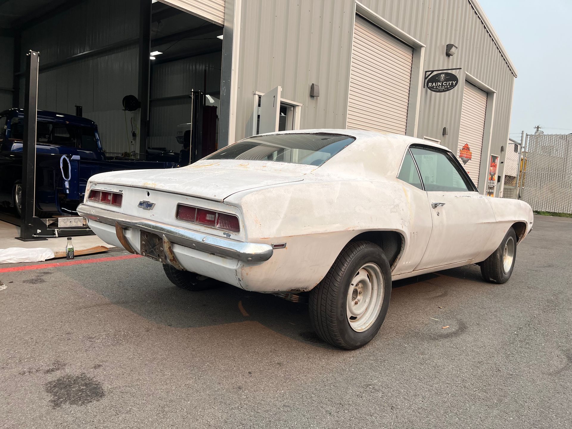 A white car is parked in front of a garage.