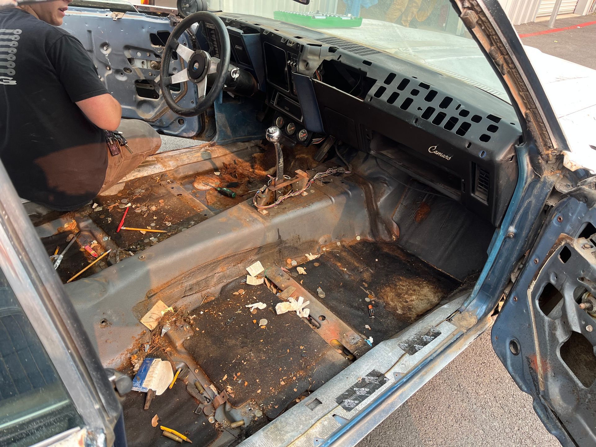 A man is working on the interior of an old car.