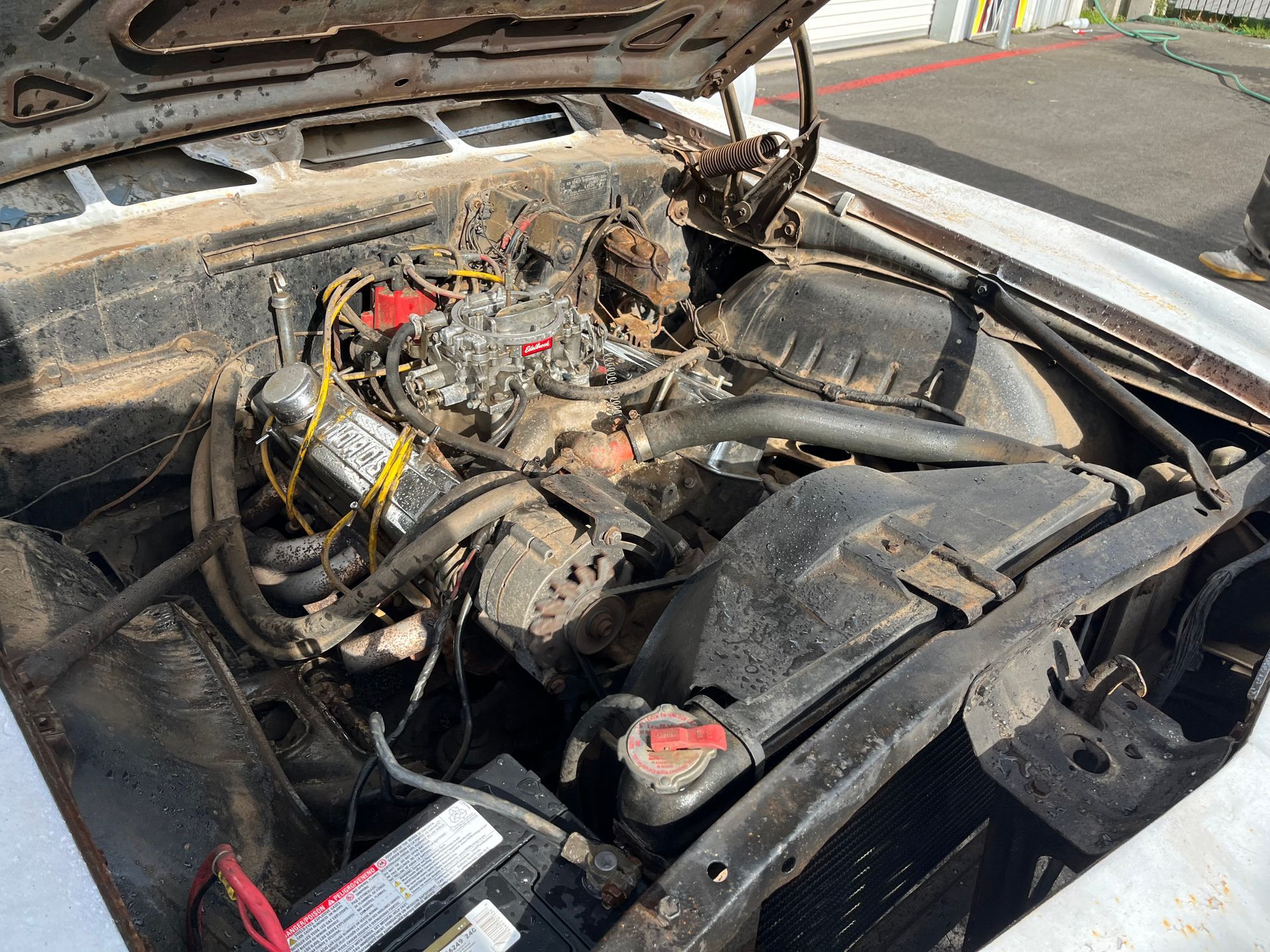 A close up of a car engine with the hood open.
