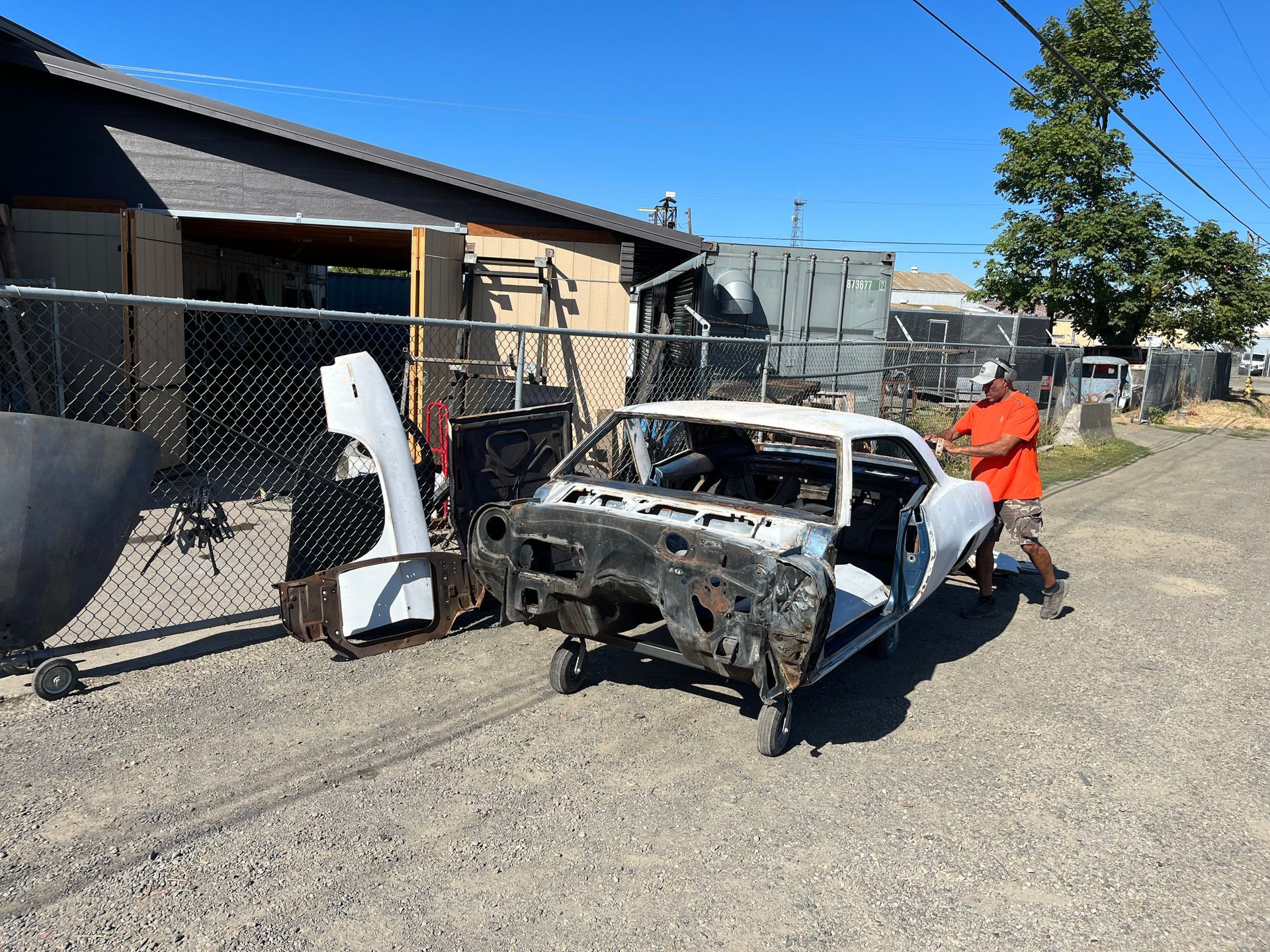 A man is working on a white car in a garage.