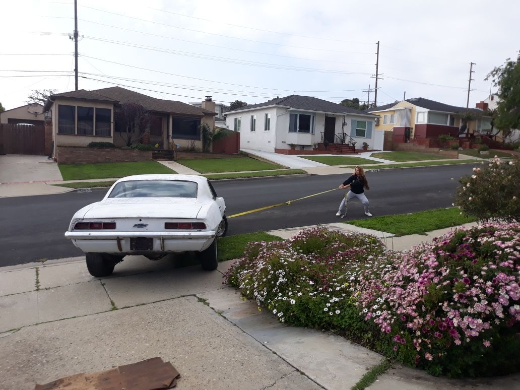 A white car is parked on the side of the road