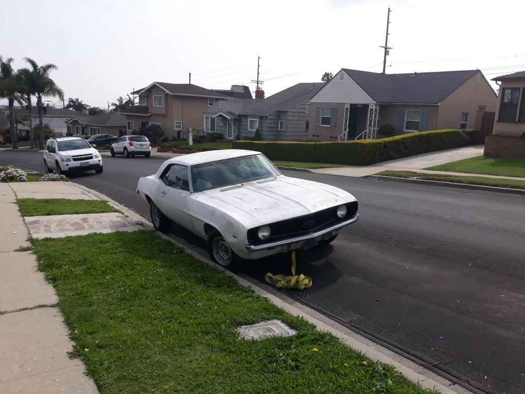 A white car is parked on the side of the road in a residential neighborhood.