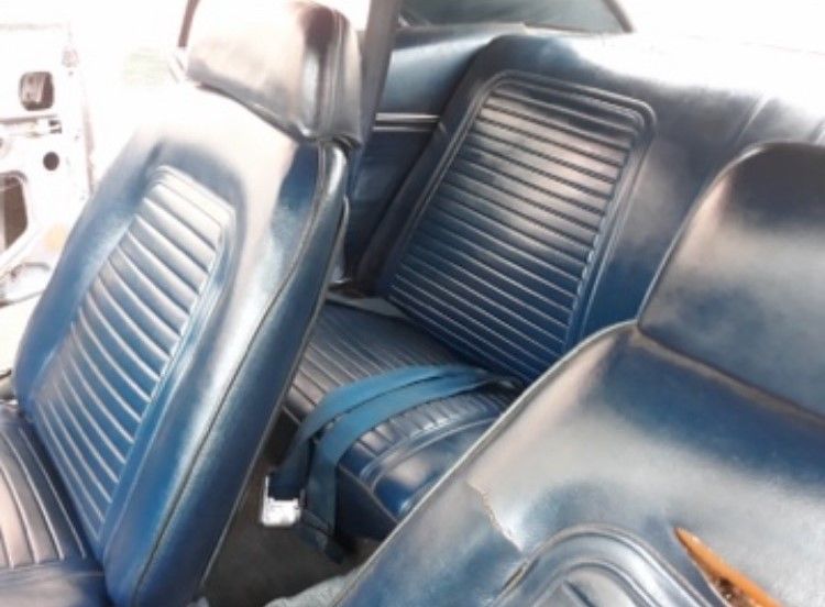 The back seat of a car with blue seats