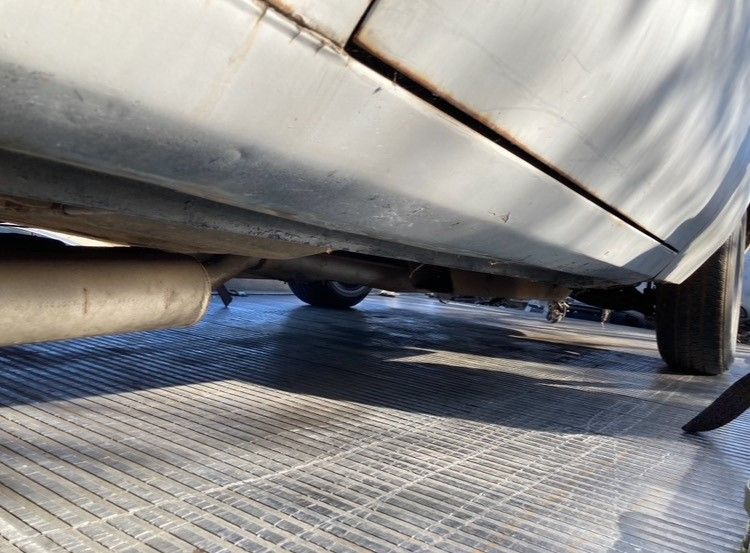 A silver car is parked on a tiled floor