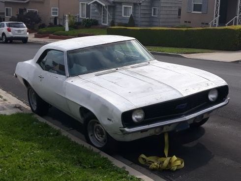 A white car is parked on the side of the road.
