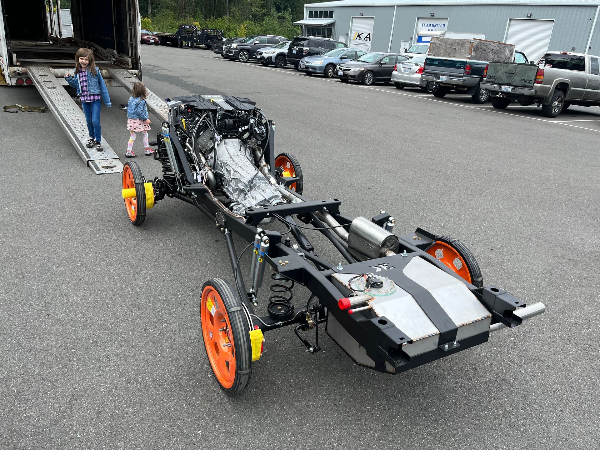 A car is being towed down a ramp by a truck.