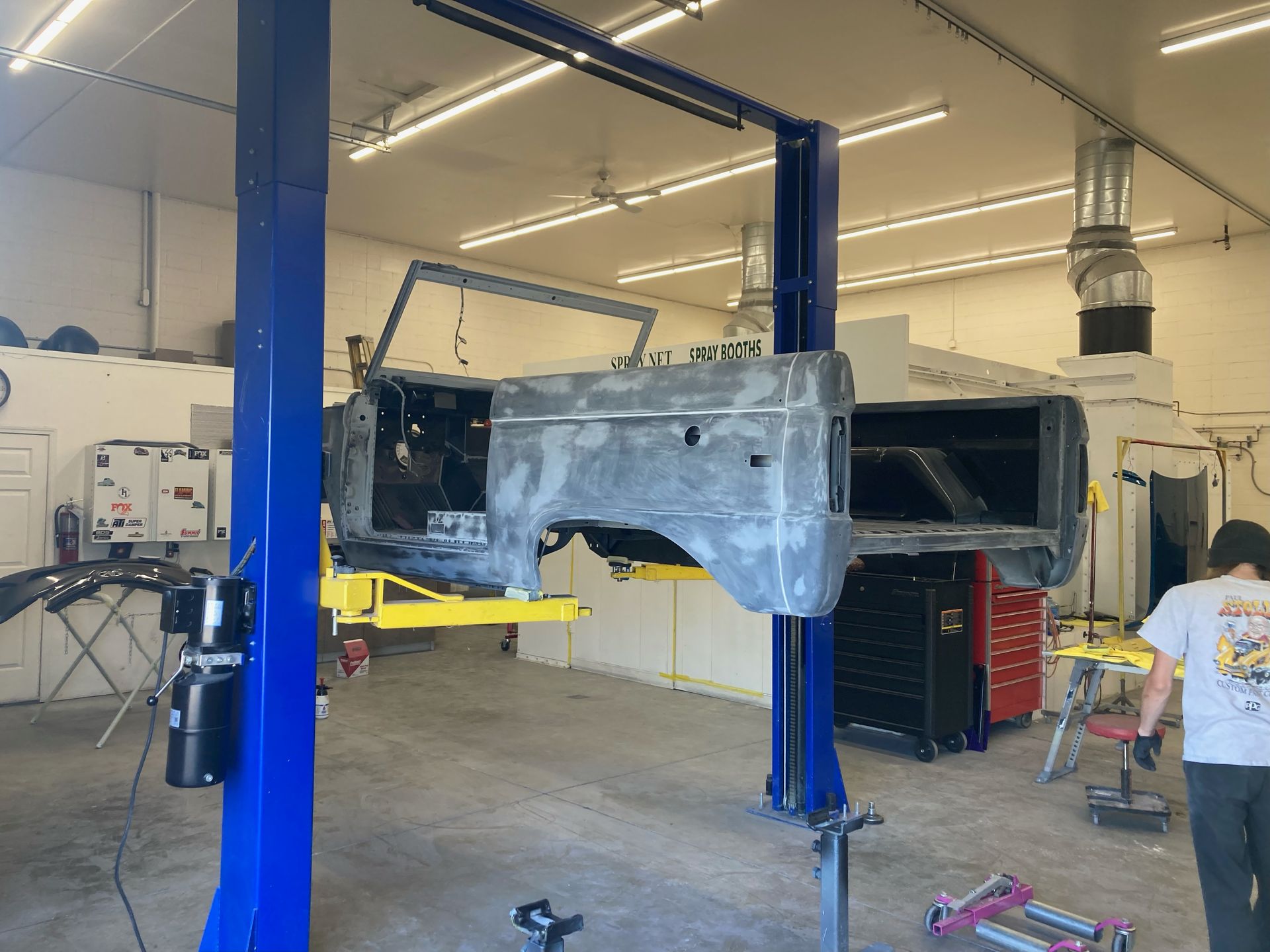 A car is sitting on a lift in a garage.